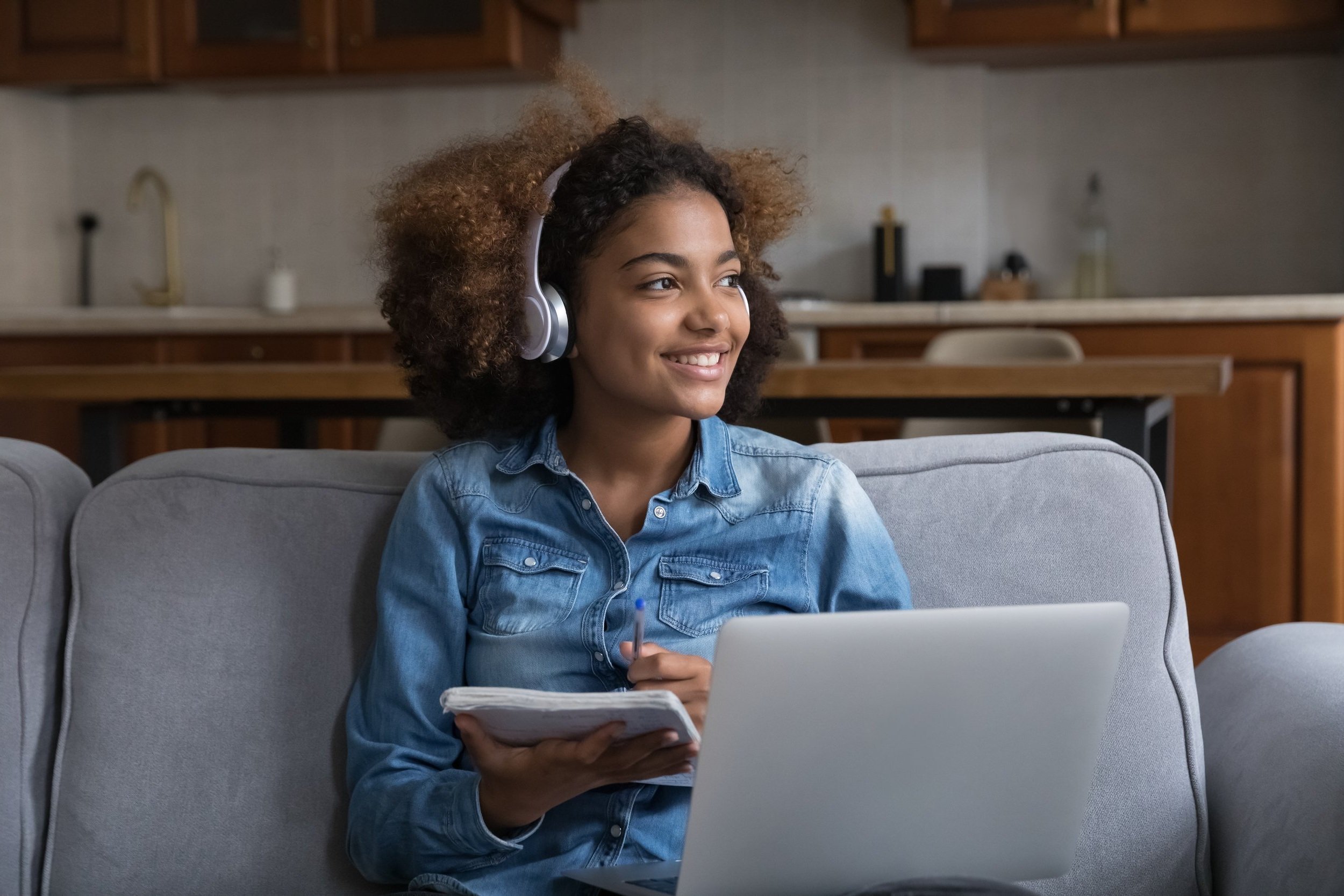 Black+girl+writing+in+notebook+with+laptop+and+headphones.jpg