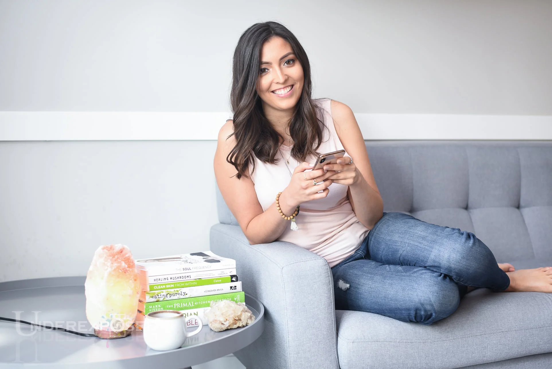 Denver Headshots photographer capturing Branding photography of woman on couch with phone and books