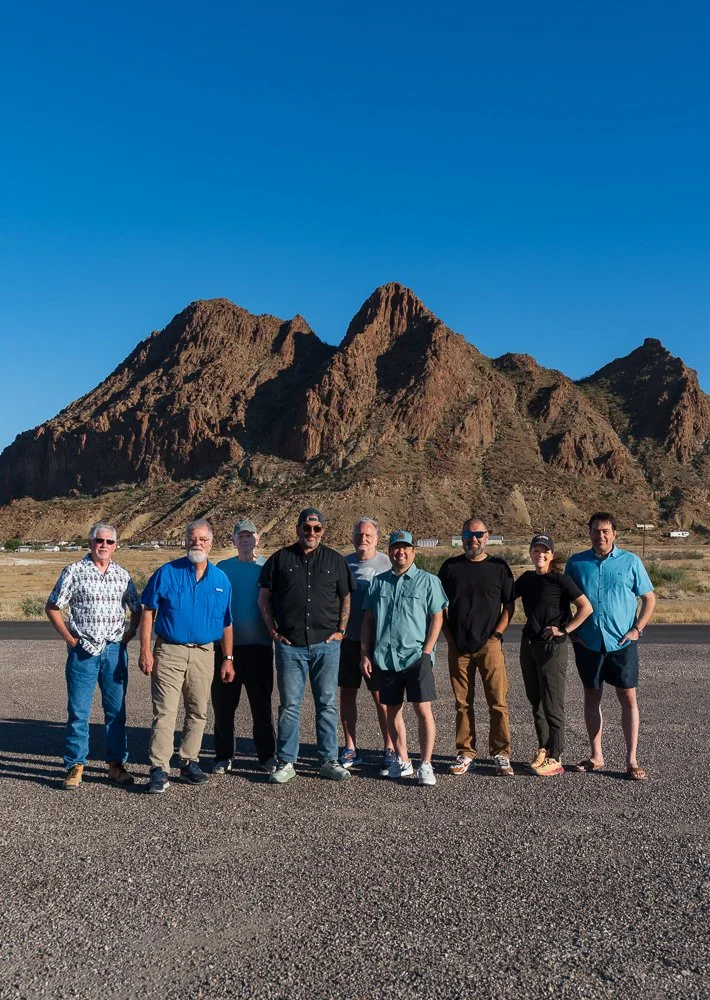 Two cameras mounted on tripods capturing a landscape at sunset