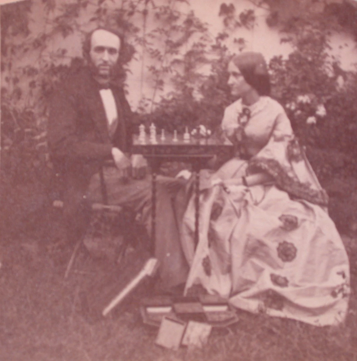 Black and white photograph of Fred and Anna playing chess outside.