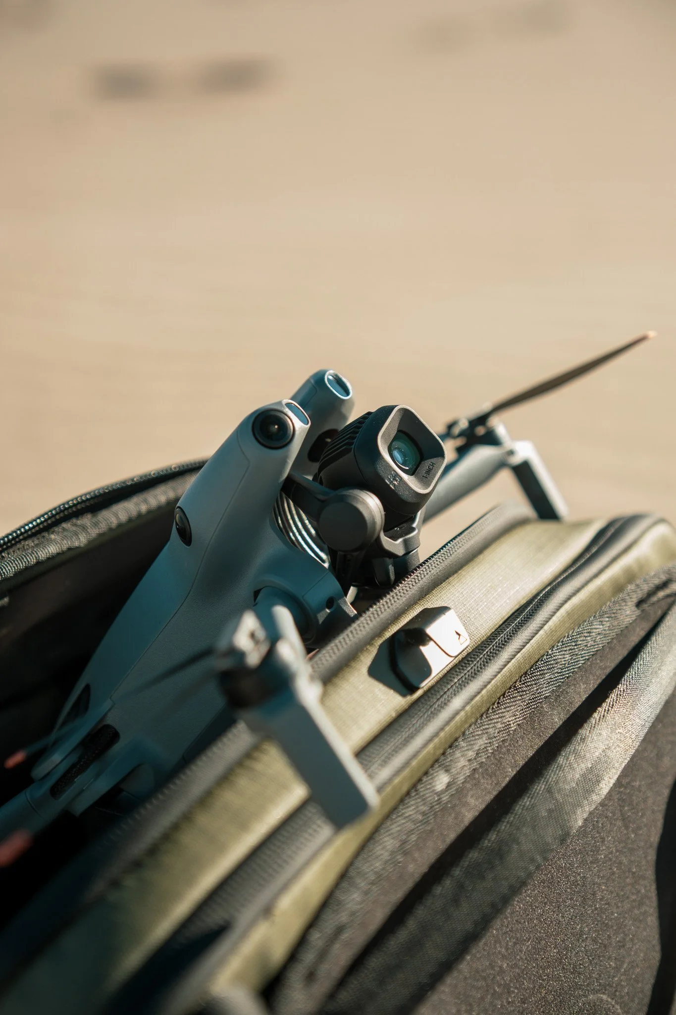 A drone inside an open backpack on a light-colored surface.