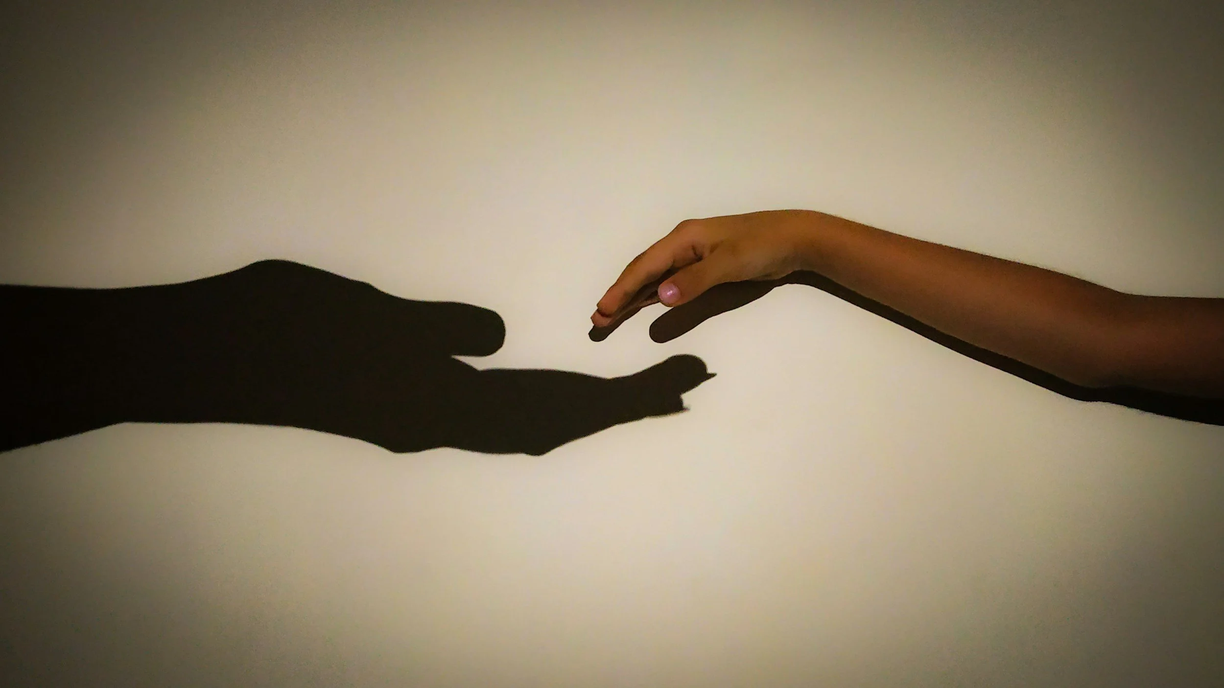 A child's hand and the silhouette of a parent's hand