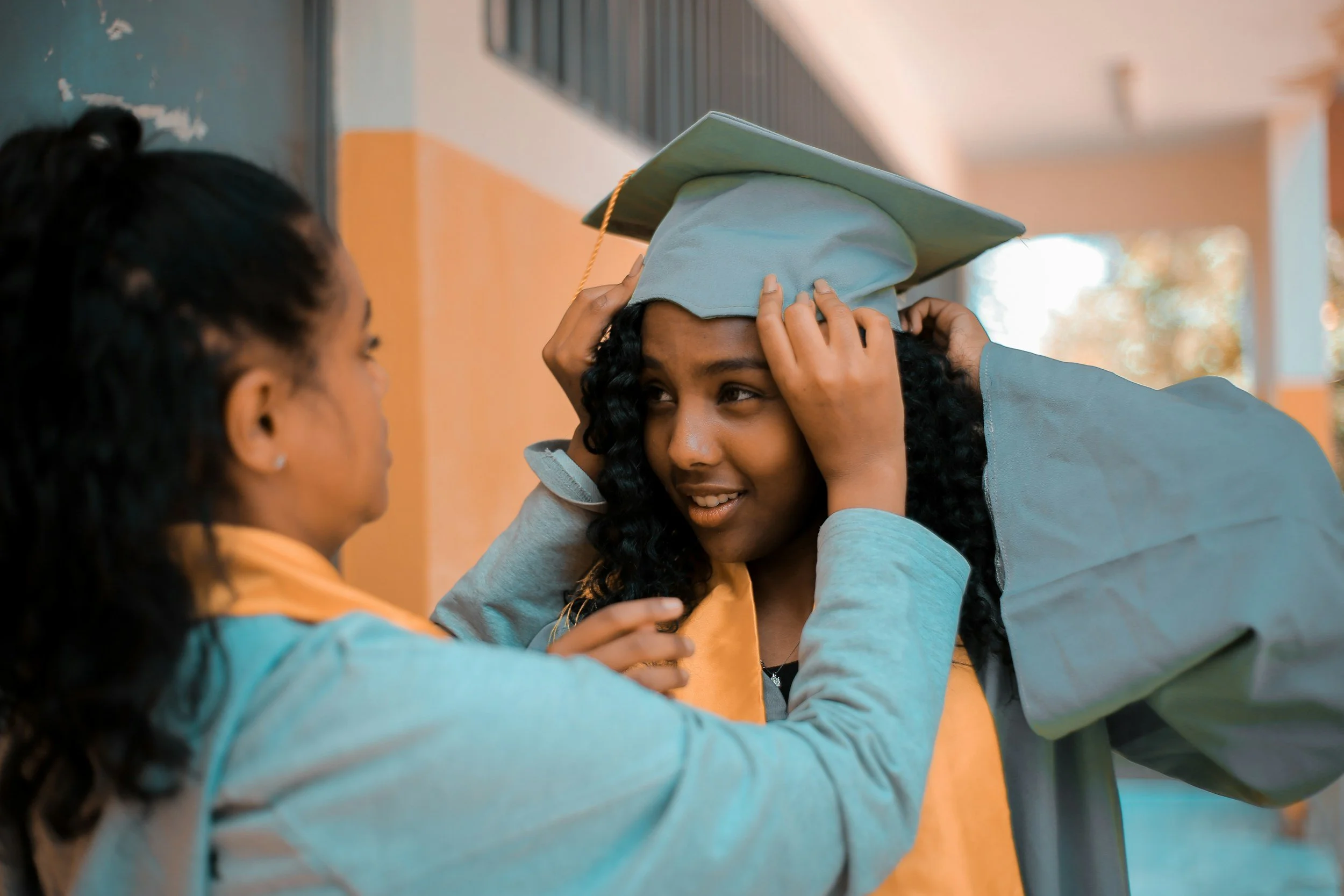 girl adjusting another girl's graduation cap