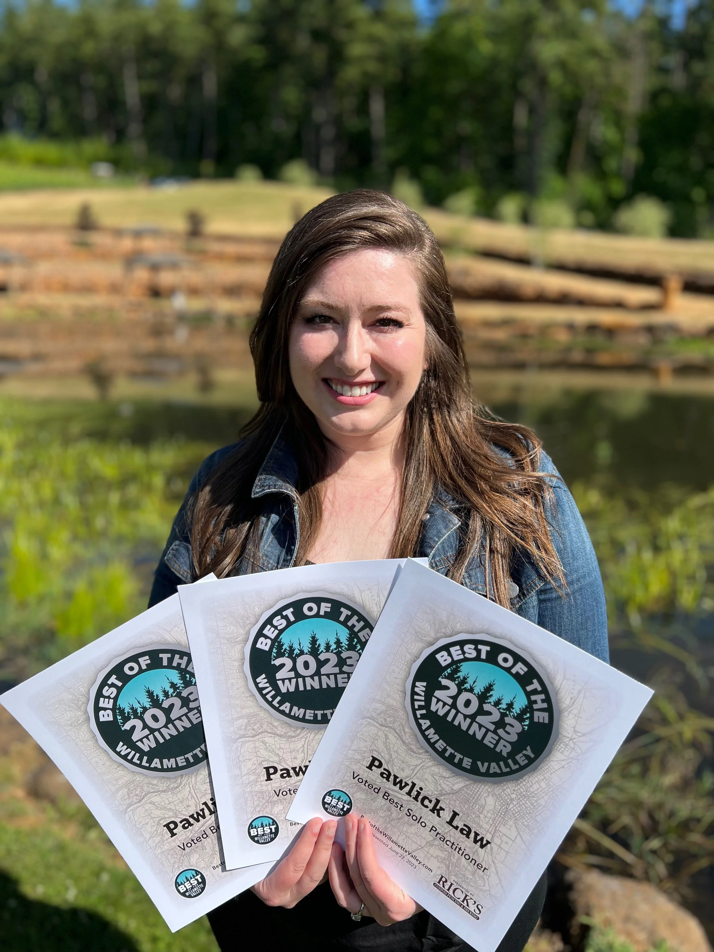 Kathryn Pawlick holds three silver Best of the Willamette Valley 2023 award certificates with at Eola Hills Winery.