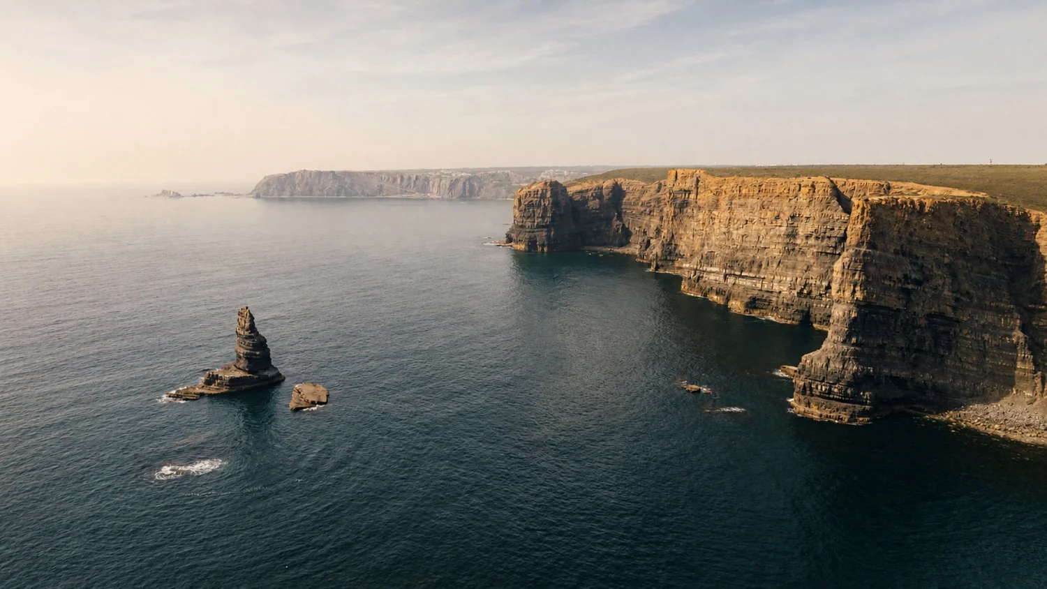 Sea stack and layered sandstone cliffs above dark Atlantic water on Portugal&rsquo;s Costa Vicentina