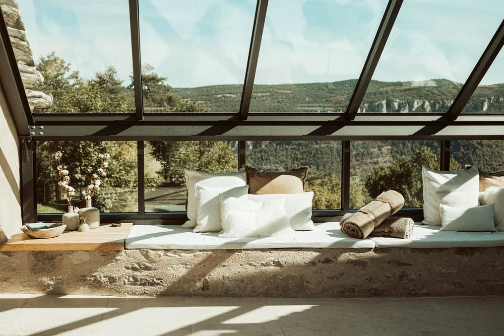 Glass lounge at L'Esprit d'Almières overlooking the limestone hills of the Causses and Cévennes