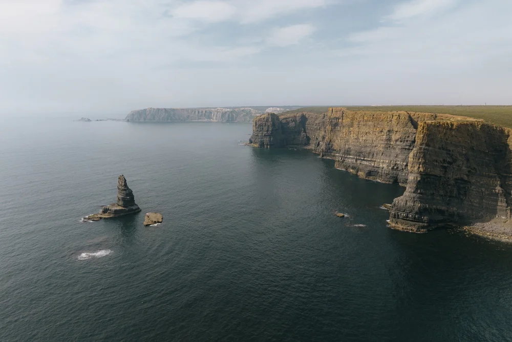Aerial view of dark Atlantic cliffs and sea stacks along Portugal’s Costa Vicentina