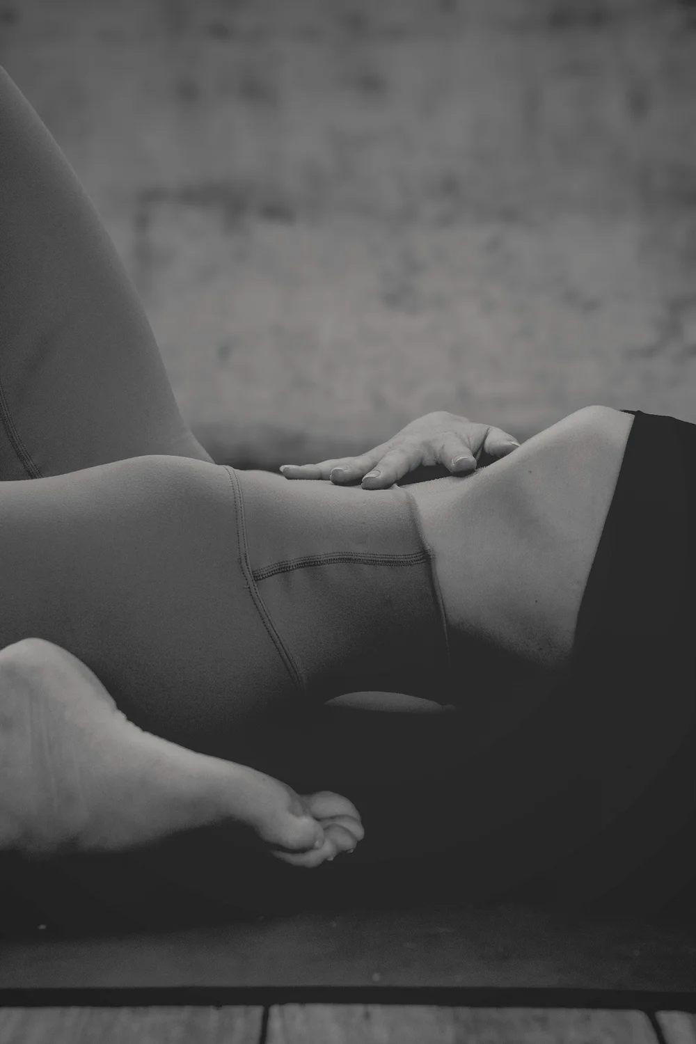 Close-up of hands-on movement guidance supporting a participant’s bent leg during practice