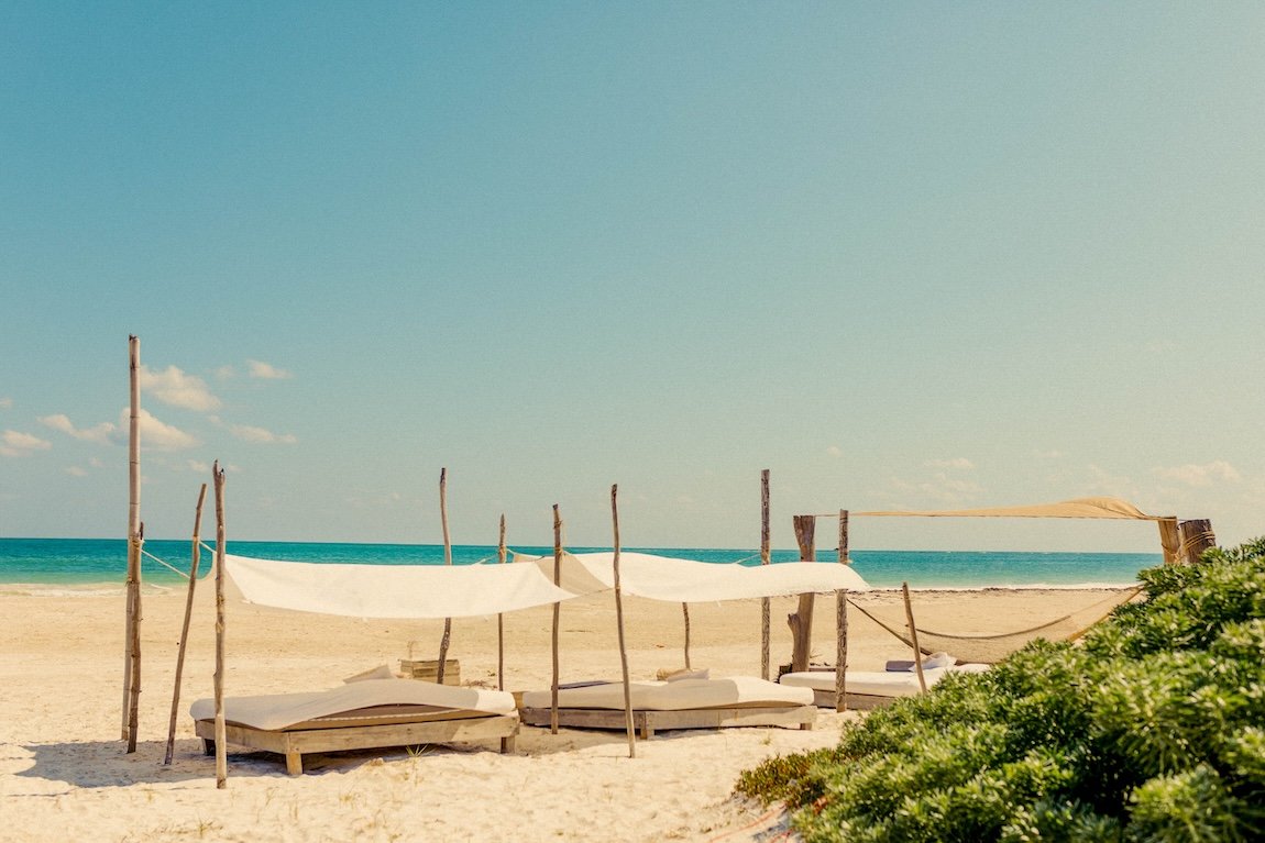 Private beach and hammocks at a luxury yoga retreat in Tulum, Mexico.