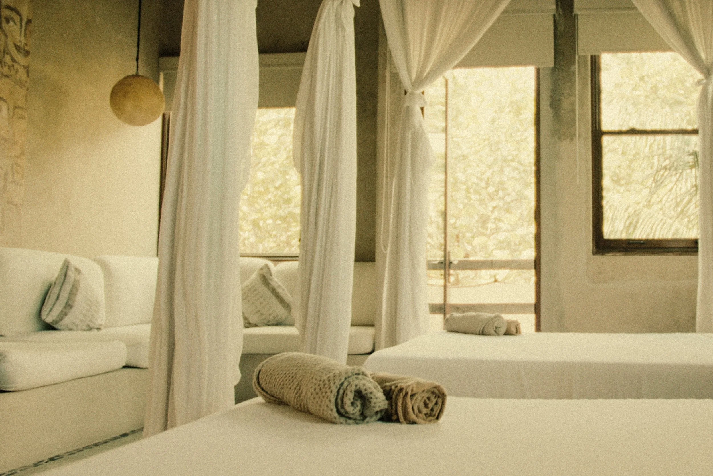 Light-filled double queen canopy suite interior — luxury wellness retreat accommodations near Tulum, Mexico