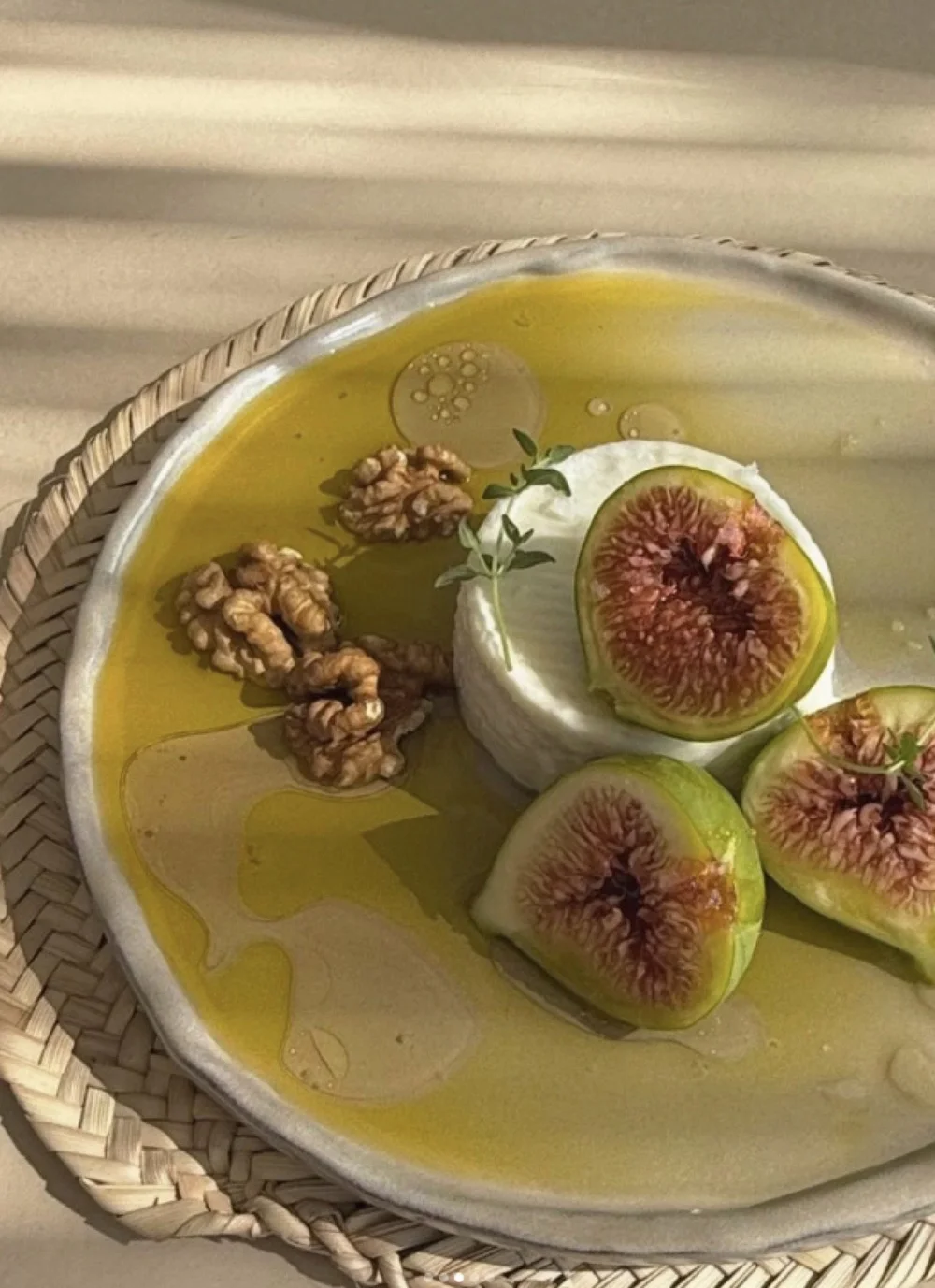 Fresh figs, soft cheese, walnuts and olive oil arranged in warm sunlight for the Casa table in Portugal