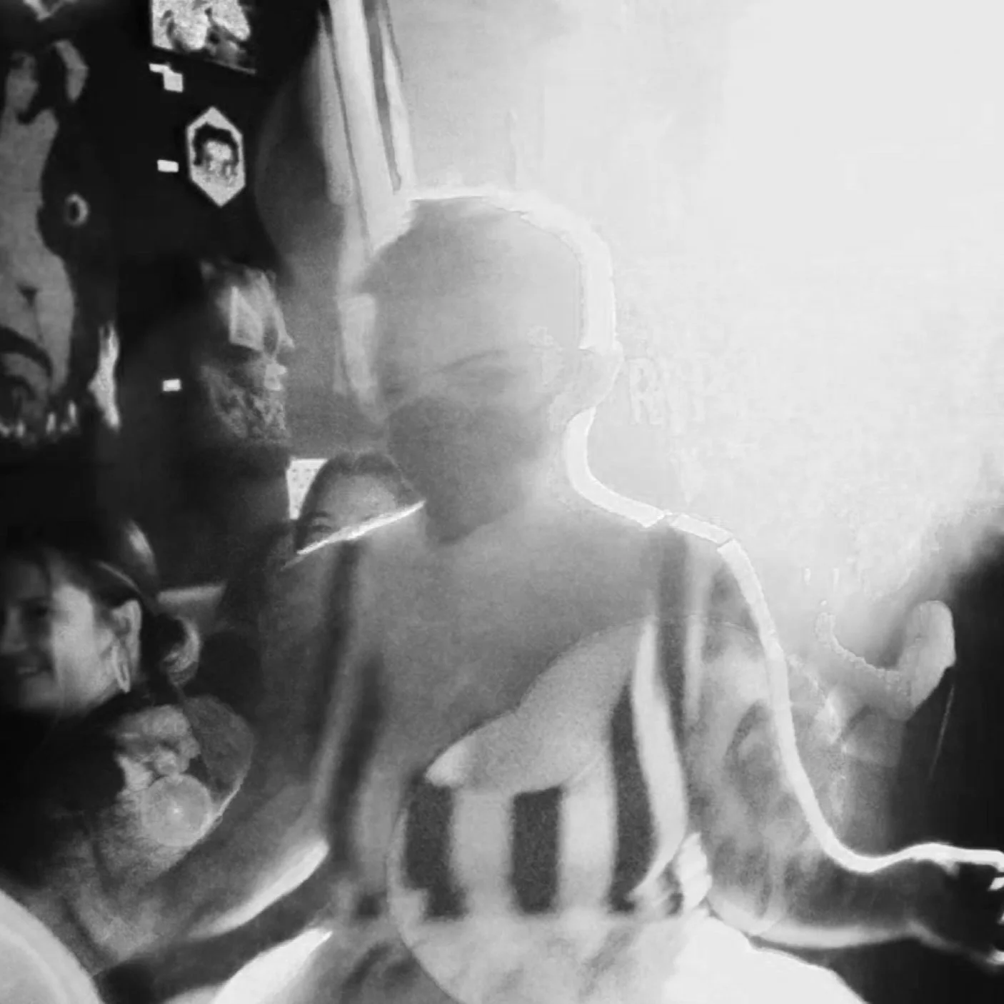 image still of Allie Soreass performing, wearing a mask, has short hair, and a spotlight is on them