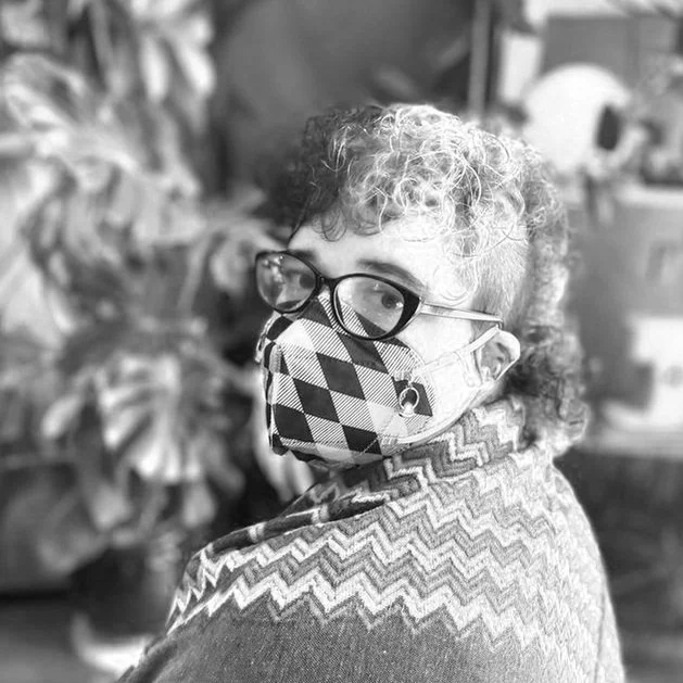 Blooms headshot, short hair, wearing glasses with a patterened mask