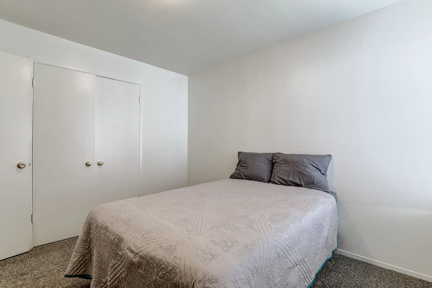 This image includes another bedroom with a double-doored closet.