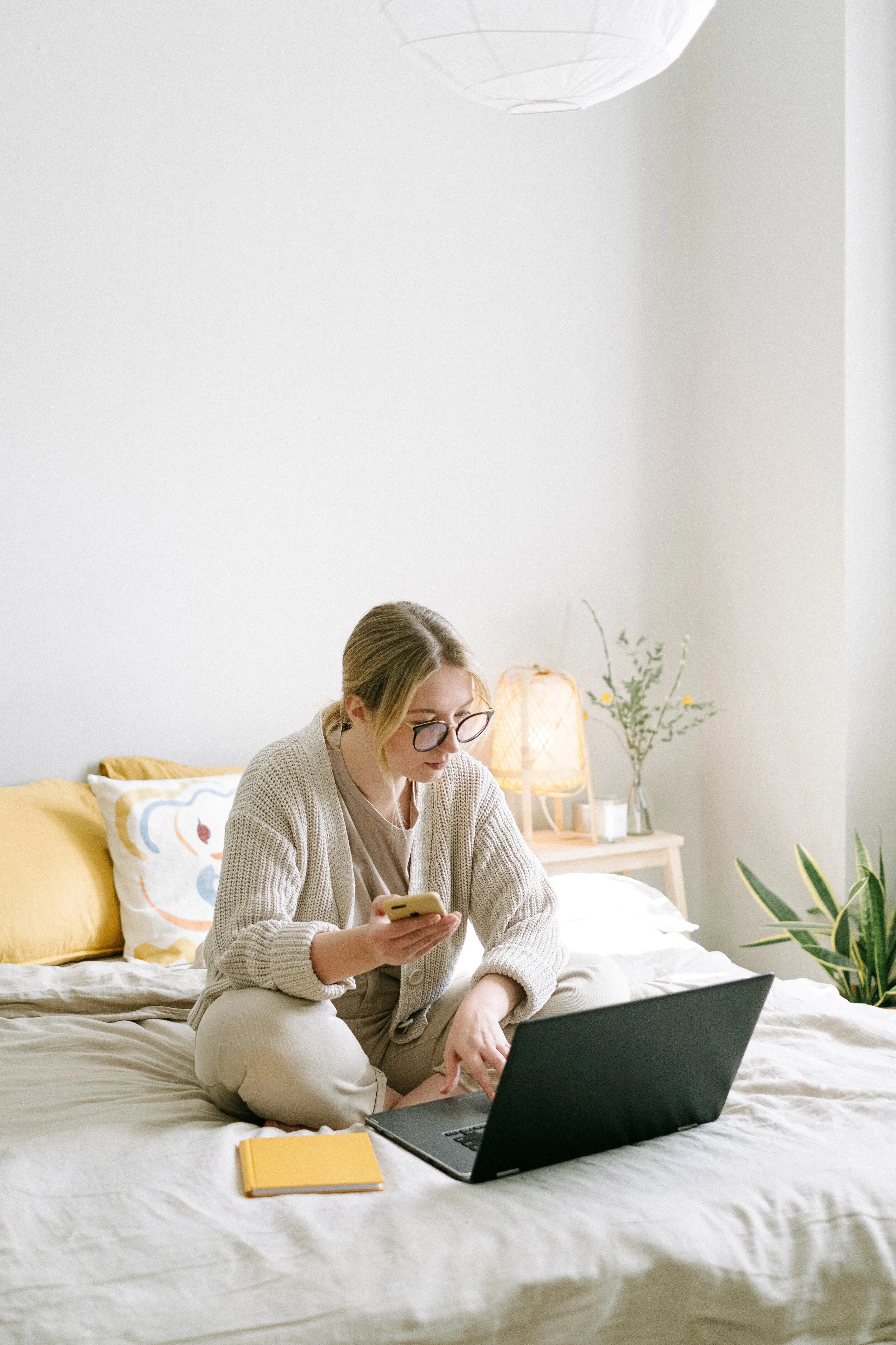 photo-of-woman-sitting-on-bed-while-using-black-laptop-4458553.jpg
