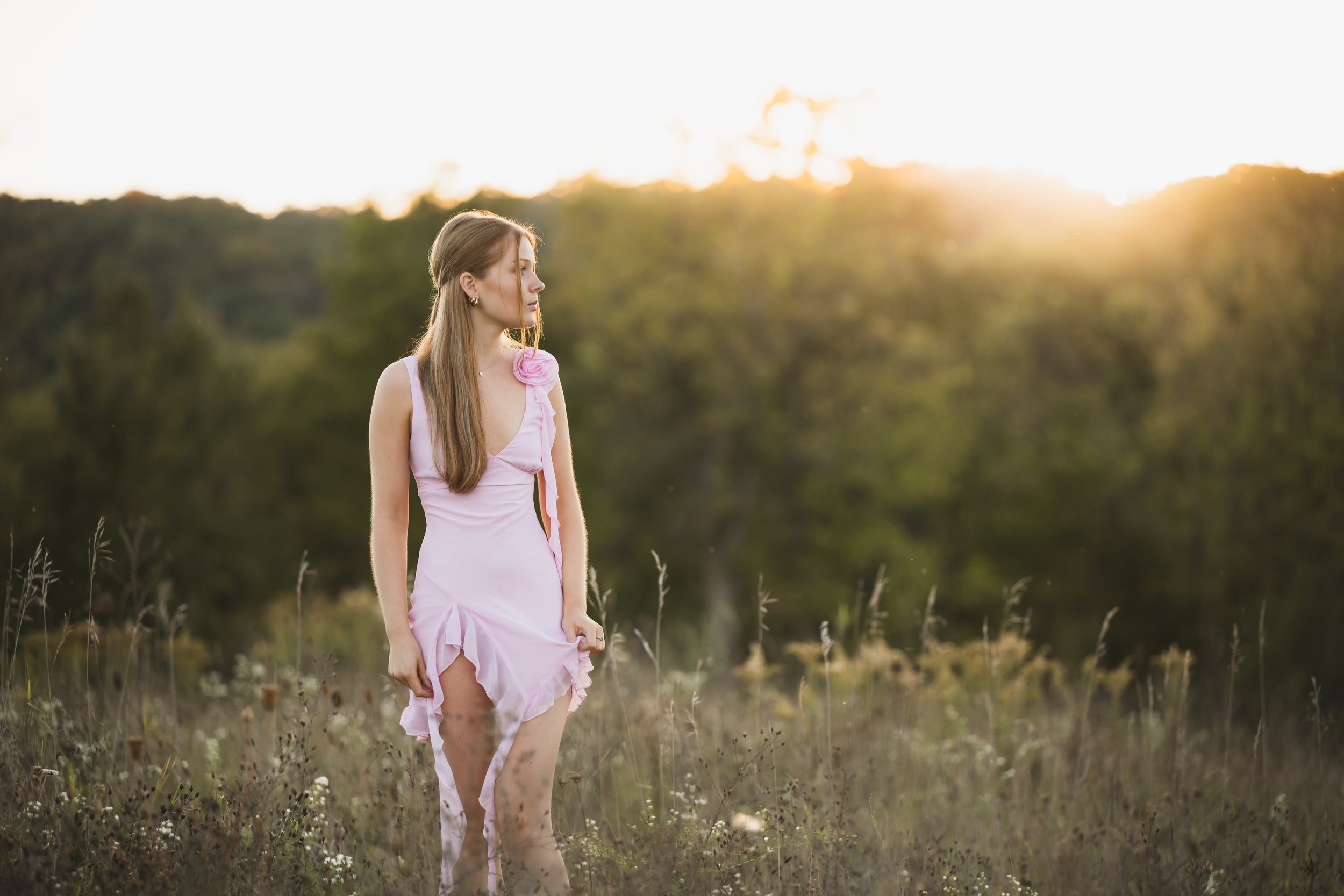 Senior portrait in a field at  golden hour
