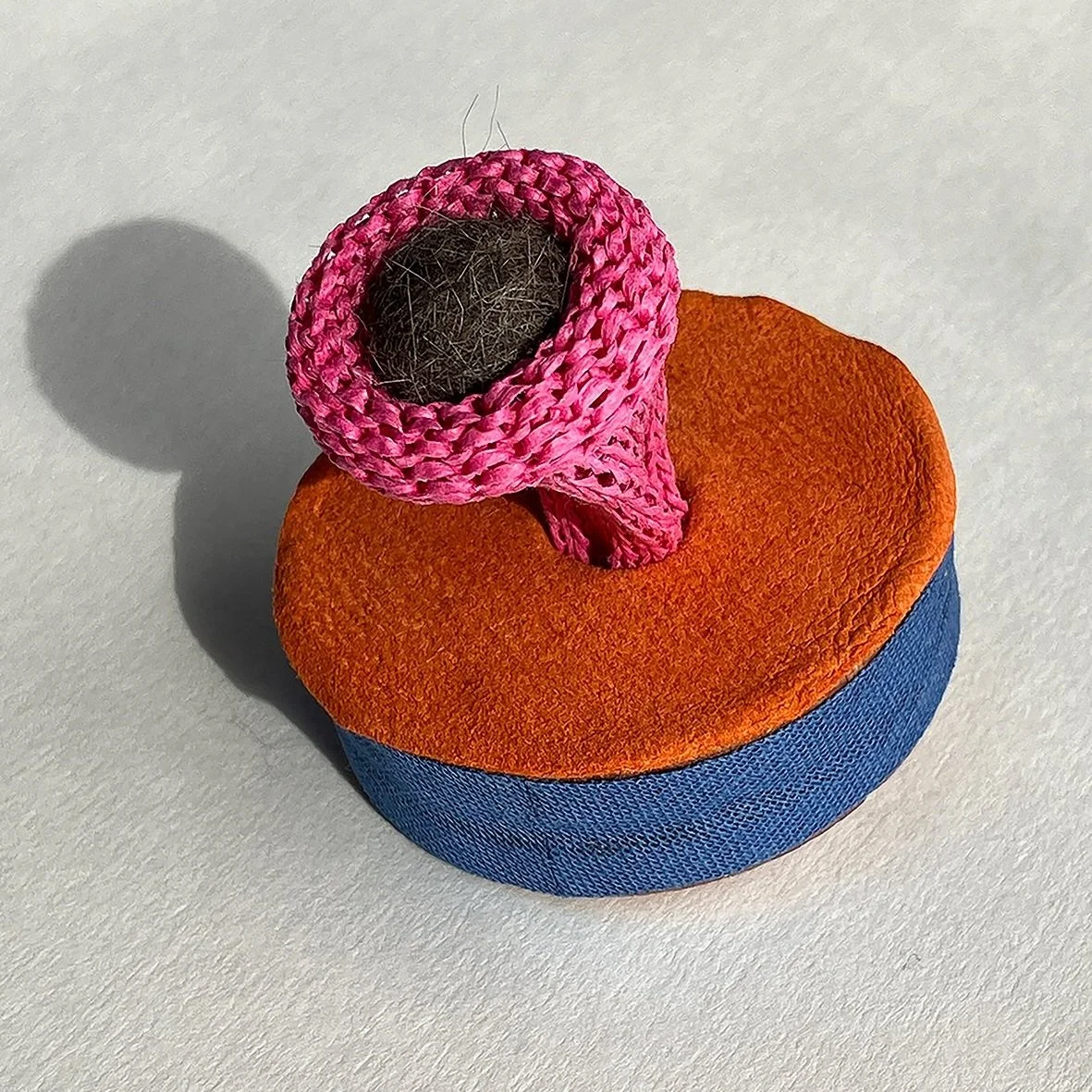 Furball, 2023, brooch/ felted cat fur (courtesy of the artist’s cat), leather, cotton, cotton thread, cedar wood, metal, 5cm x 5cm x 5cm©