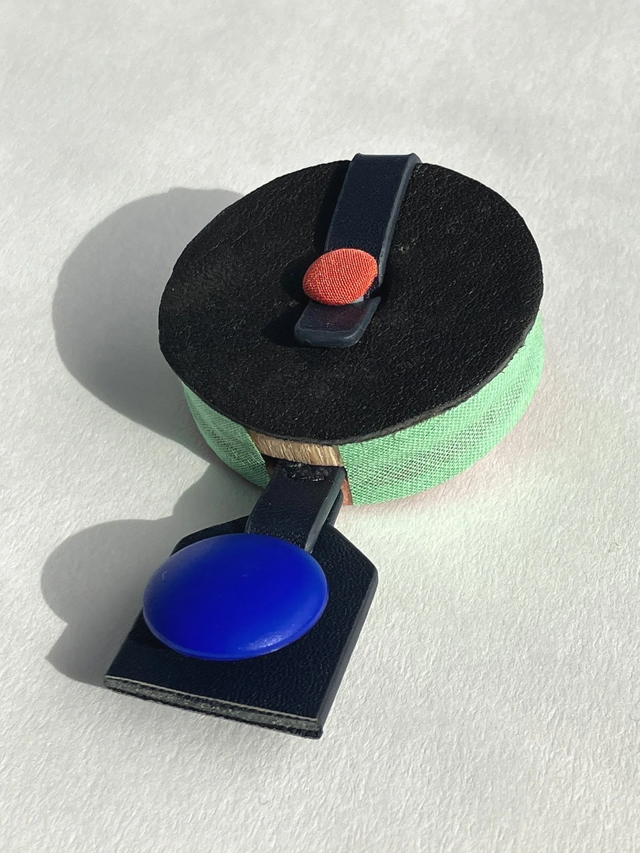 Well-rounded, 2023, brooch/ leather, plastic buttons, PU leather, cotton, polyester thread, cedar wood, metal, 5cm x 8.5cm x 2cm©