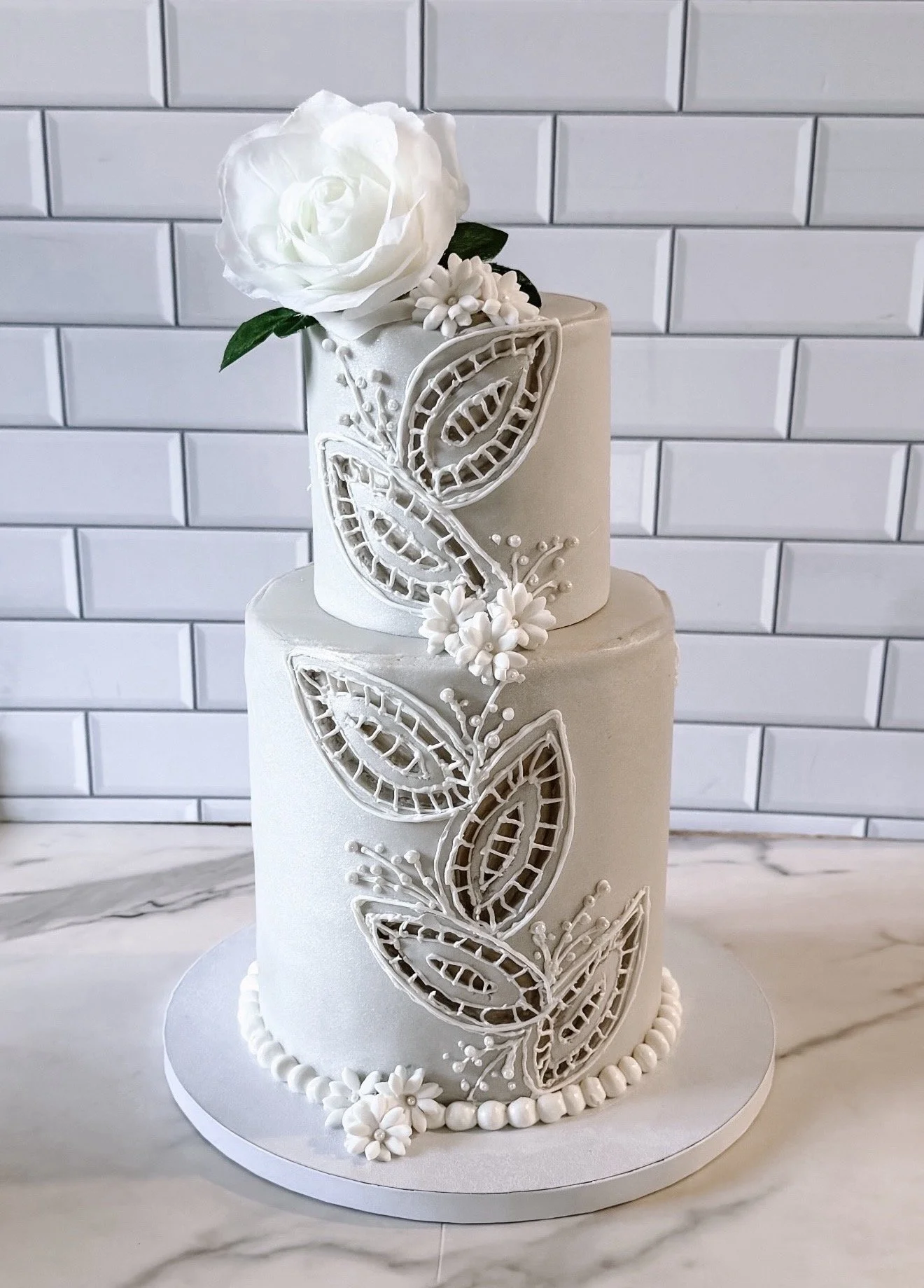 Richelieu embroidery-inspired vegan wedding cake with delicate cutwork detailing, handcrafted sugar flowers and an elegant finish
