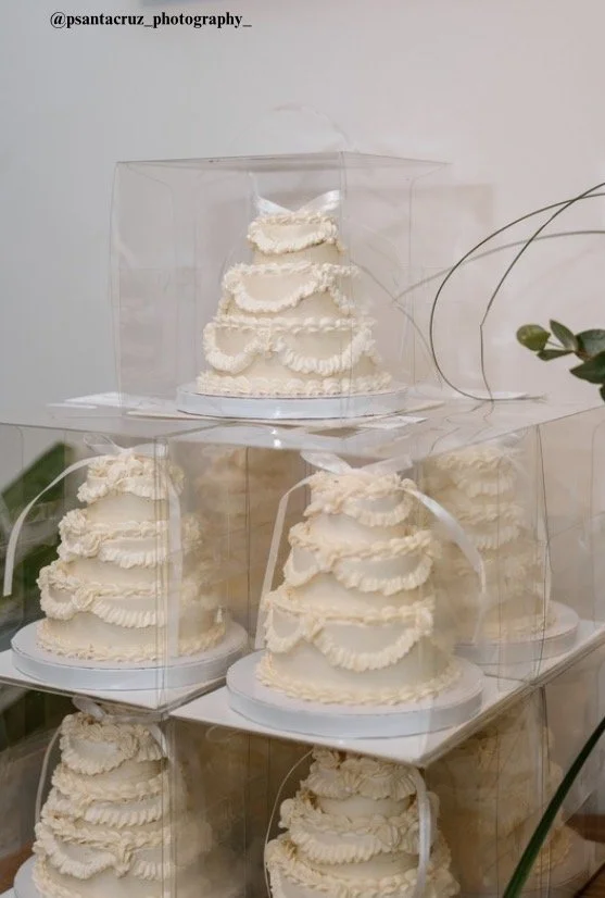 Vegan mini three-tier wedding cake favors by Veg on Board. Miniature 4 inch three-tier wedding cakes in vintage style ruffles and swags in clear boxes for wedding guests