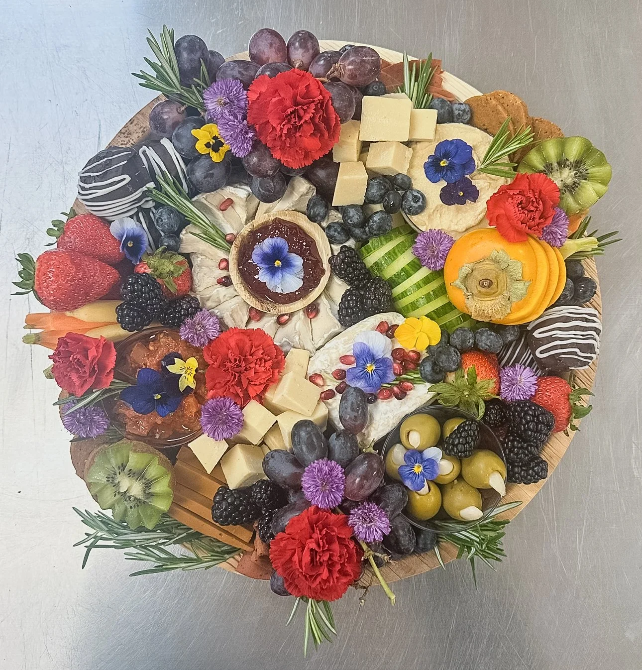 Vegan charcuterie board with fresh fruit, edible flowers, and matching wedding florals created for the bride while getting ready on her wedding day