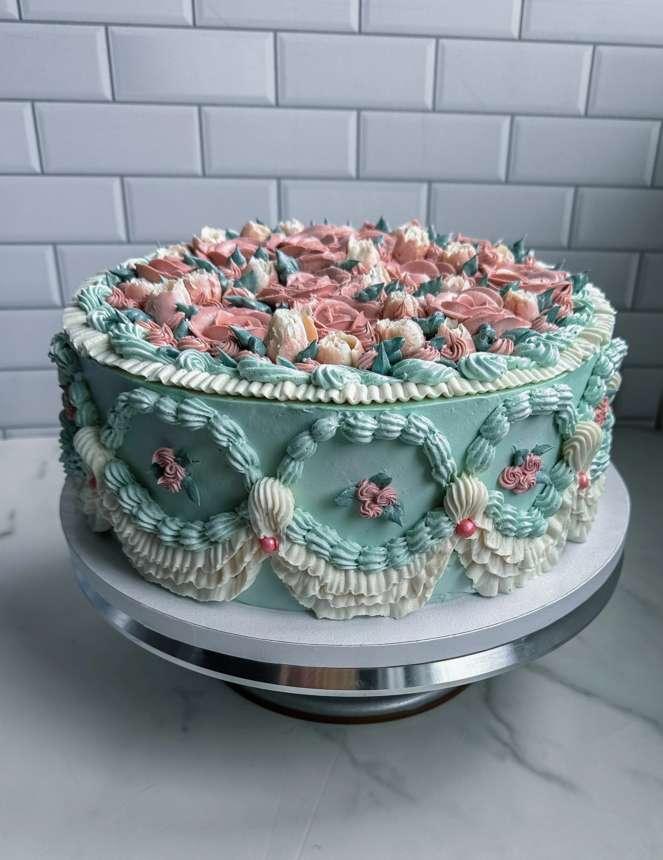 Romantic vintage-style vegan cake with floral details and textured buttercream design