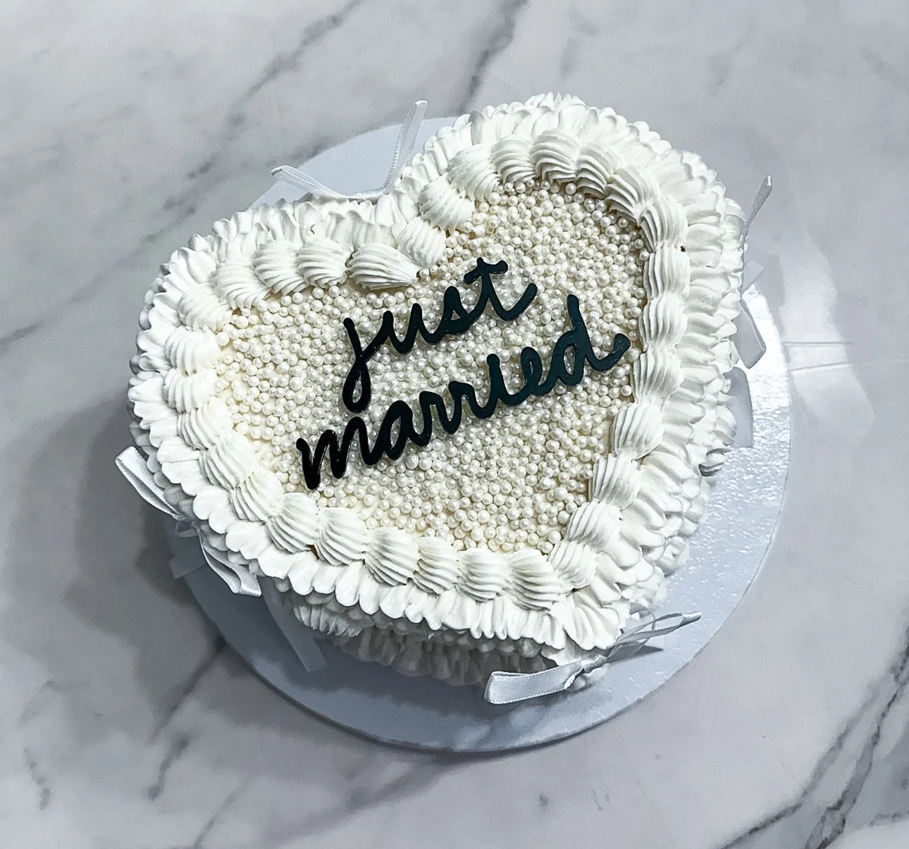 Vegan heart shaped cutting cake for couple at wedding with edible pearls and "Just Married' on top of cake 