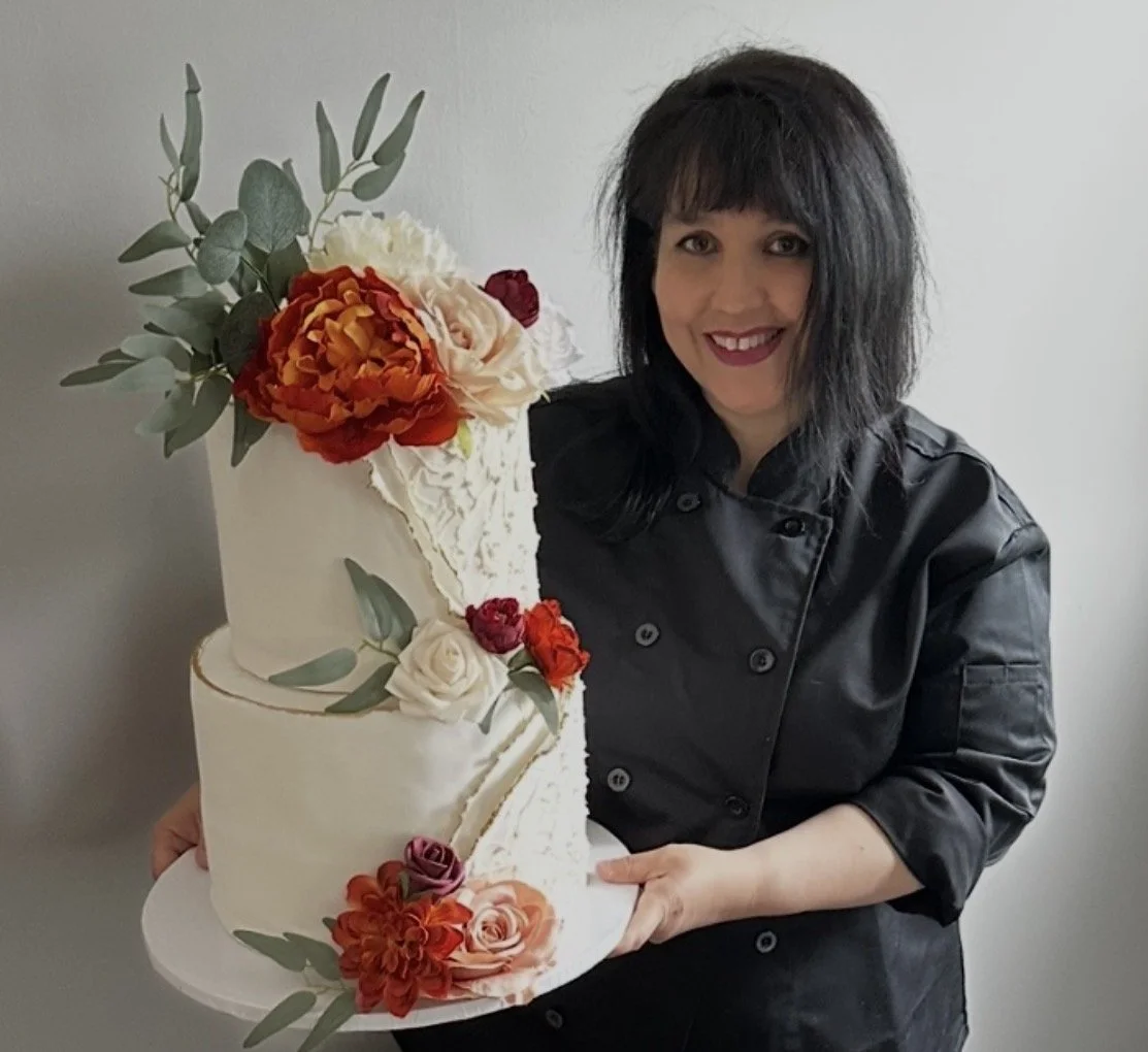 Veg on Board's cake artist and founder Irene holding a two-tier vegan cake