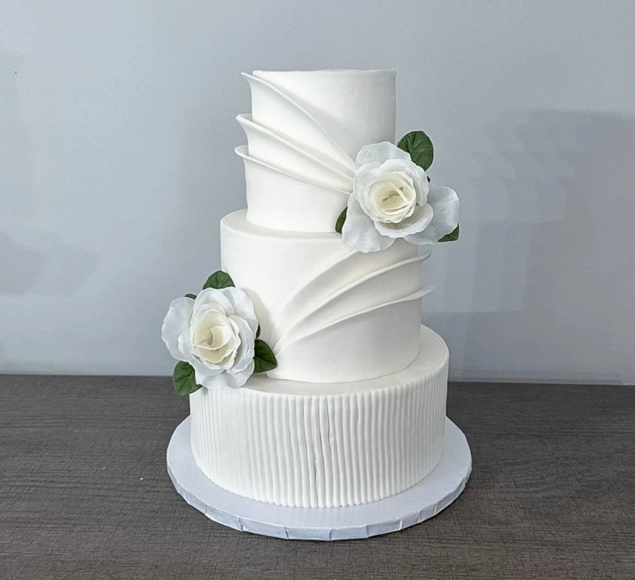 Modern white sculpted vegan wedding cake with floral details for Long Island weddings