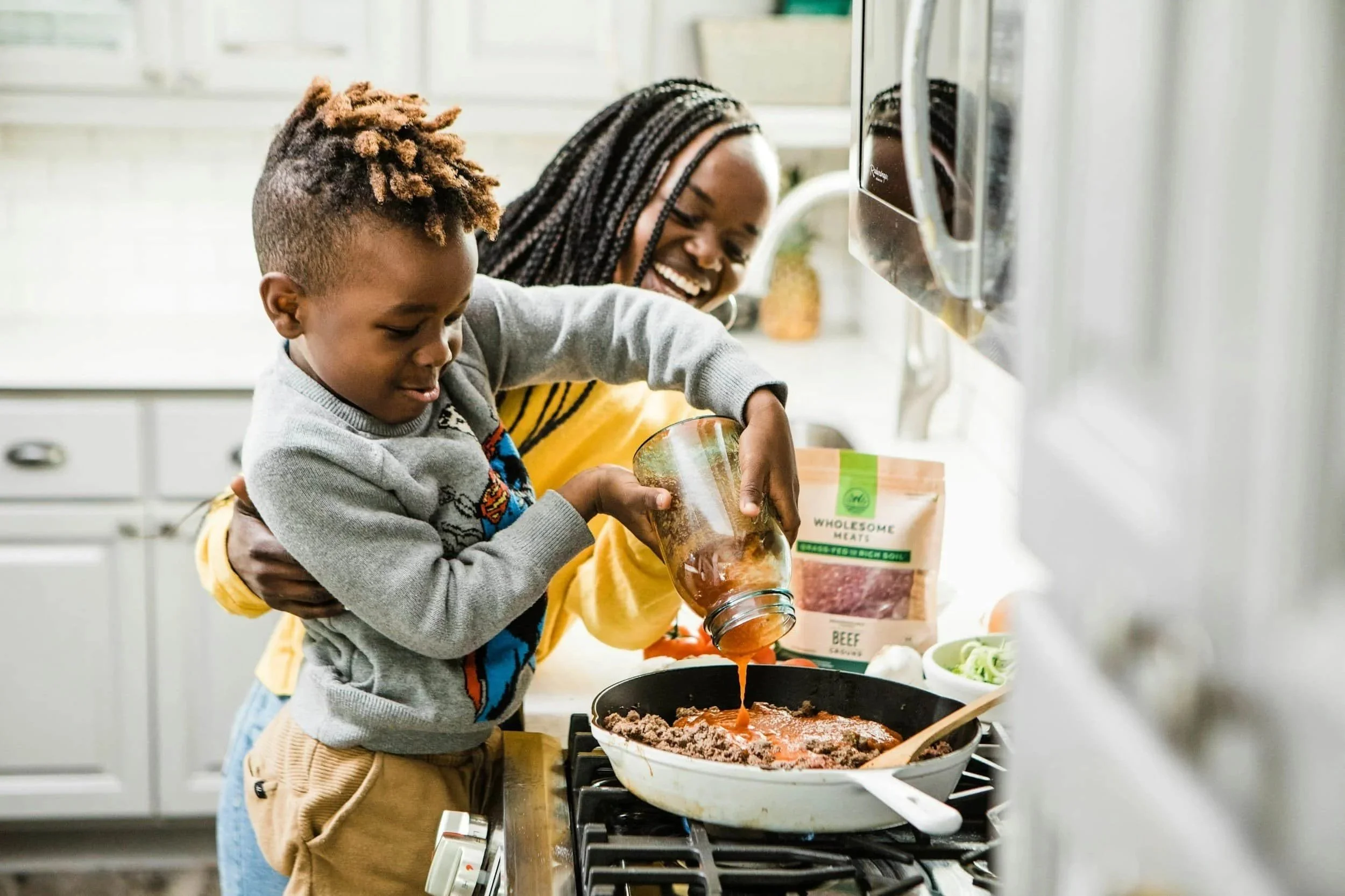 Parent helping child practice cooking skills during pediatric occupational therapy session