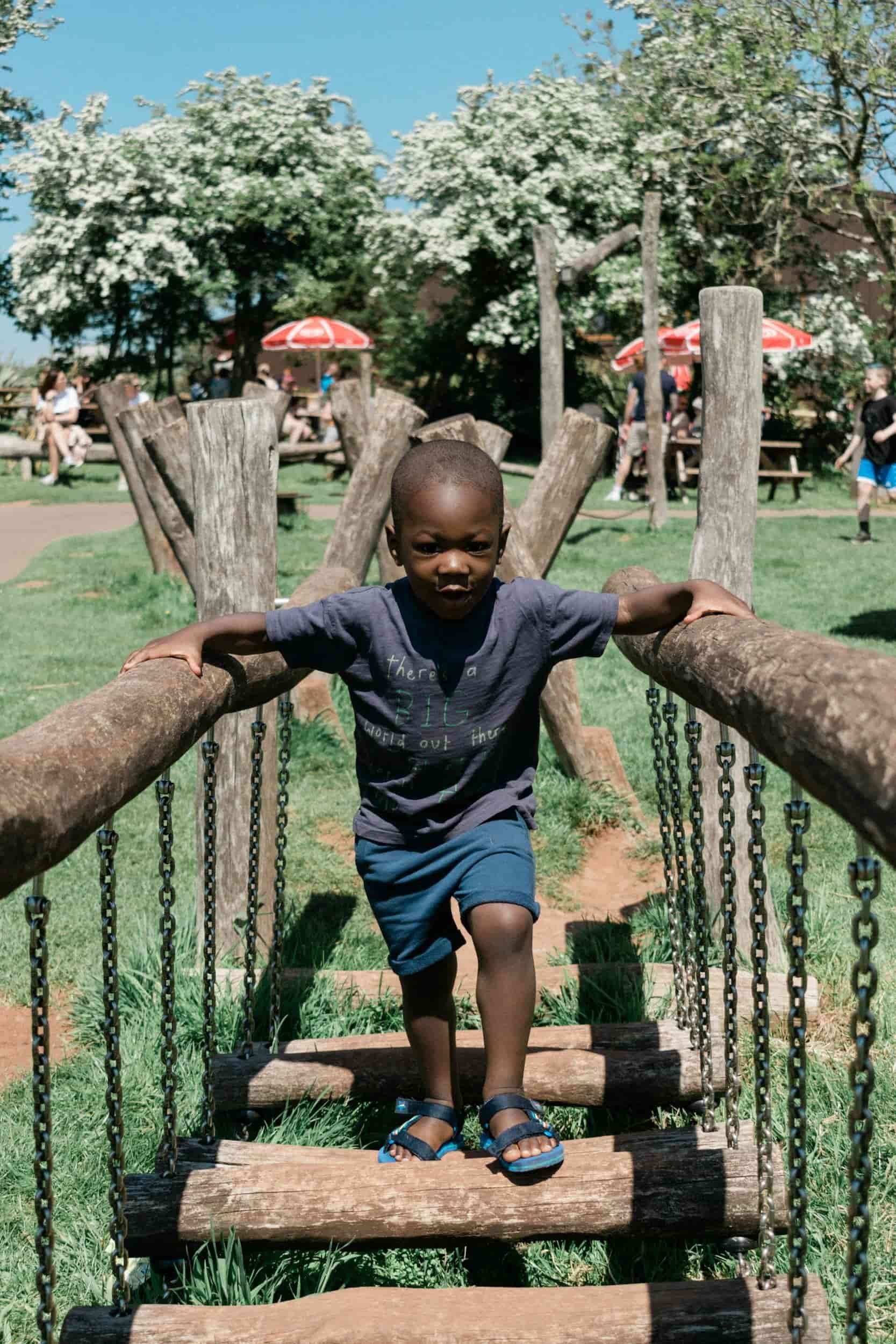 Child practicing balance and coordination on a playground bridge during pediatric physical therapy session