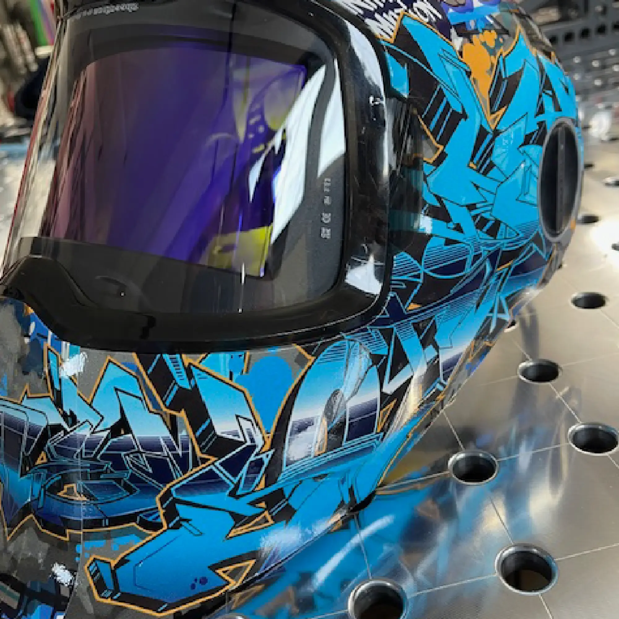 Graffiti G5-02 Welding Helmet Wrap – close-up of blue and silver vinyl surface with graffiti texture