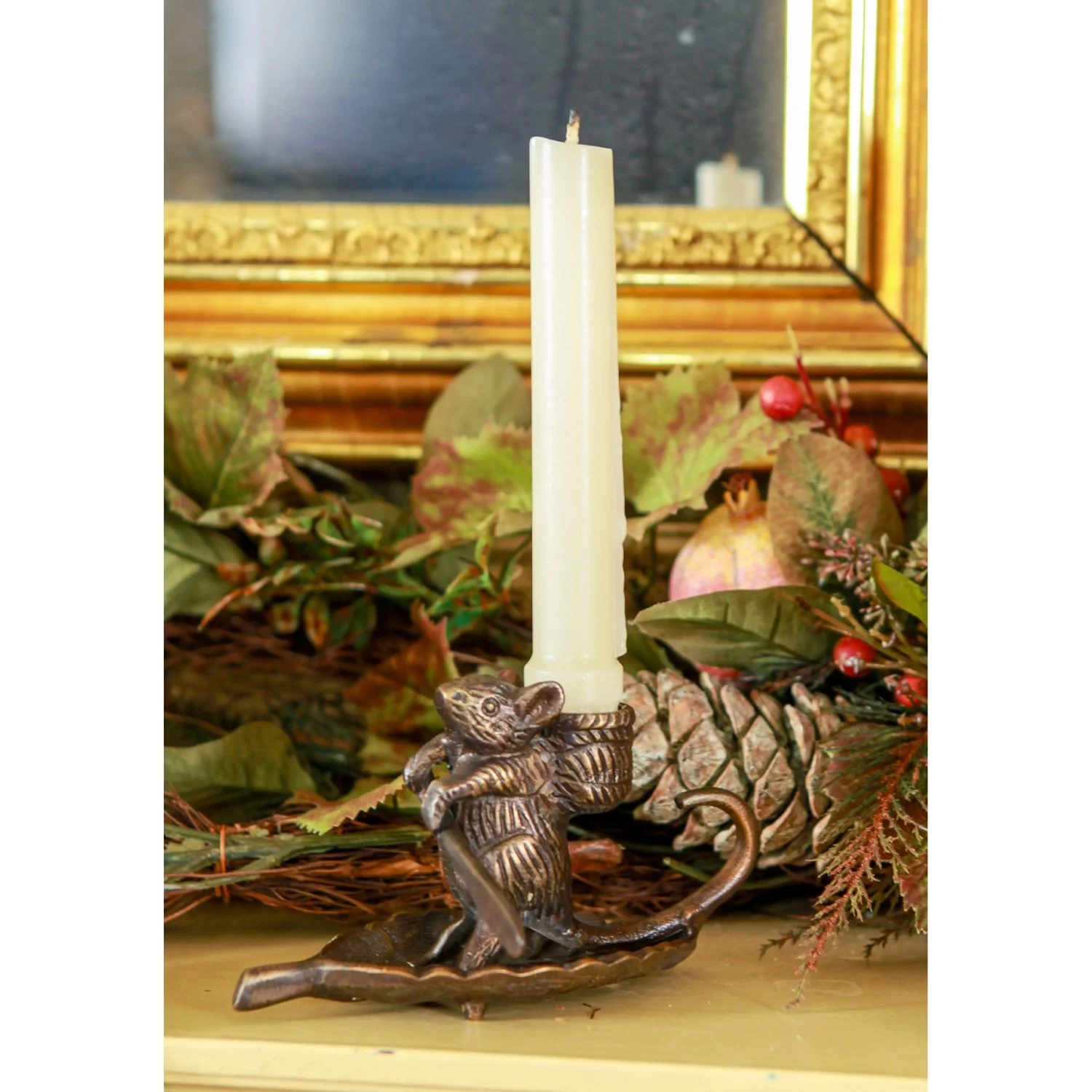 Solid Brass, antique bronze finish. Shaped as a mouse holding a paddle standing on top of a leaf like its rowing down a stream. The mouse has an open backpack that a candle stick would nestle into.