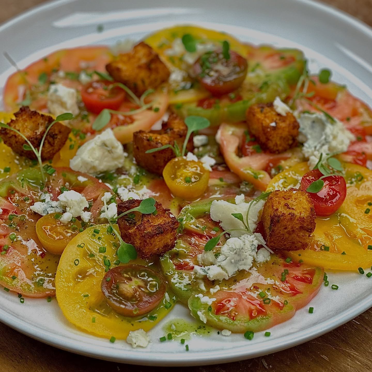Is it summer yet? Because these tomatoes are bringing the heat!
This vibrant tomato salad is loaded with Basin Hill blue cheese, fresh basil vinaigrette, micro arugula, juicy tomatoes, and crispy croutons. Simple, stunning, and summer on a plate.
#T