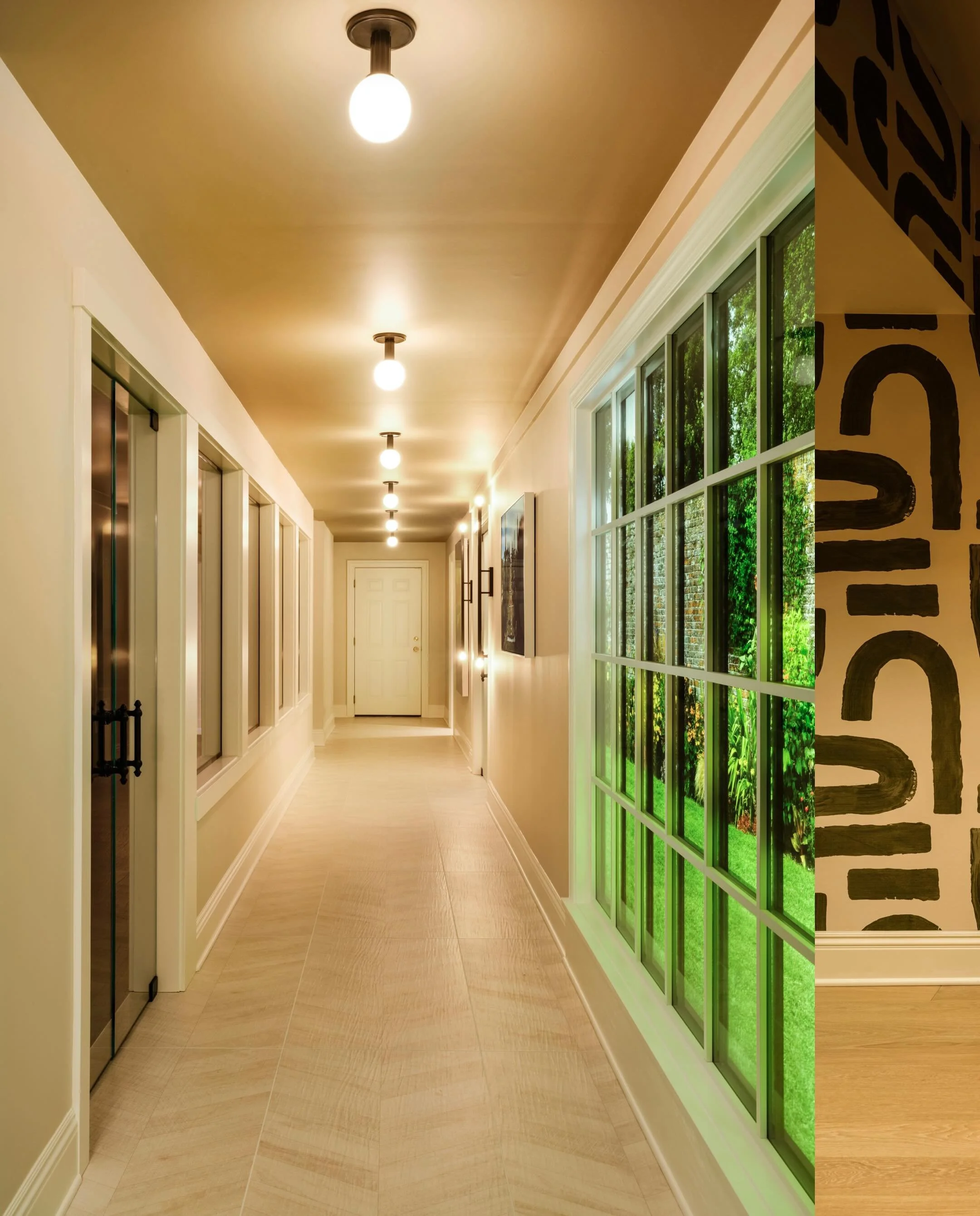 The lower level rec space at our Windmere project&hellip; a faux window gives the effect of natural light as you make your way to the massage room, golf simulator, cold plunge or gym. 

Photography by @tavolettiphoto