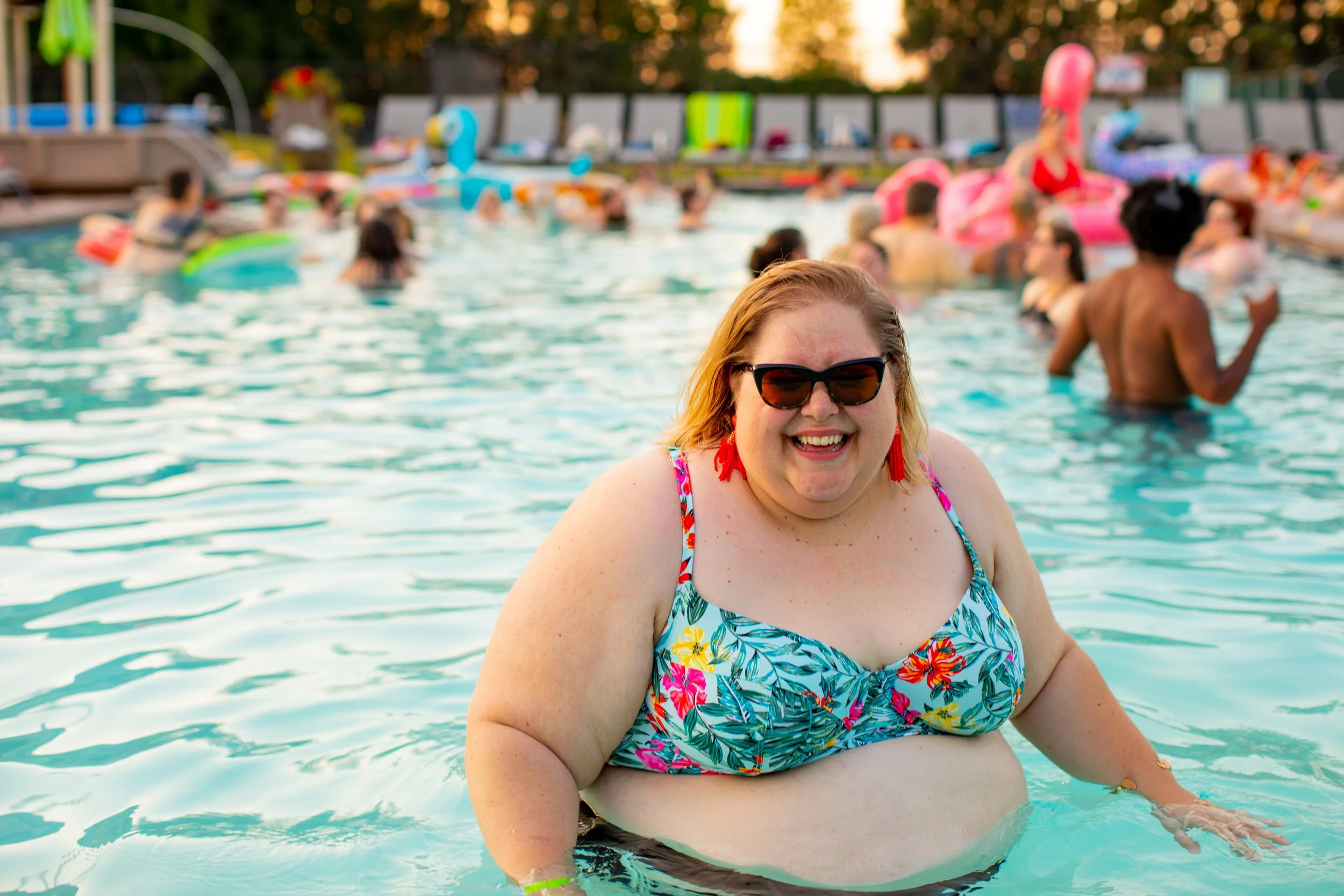 Photo a fat woman in a bikini enjoying herself at a pool party, representing how women of all sizes can feel good in their bodies with the support of a body image therapist in Los Angeles. 90049 | 90015 | 90291