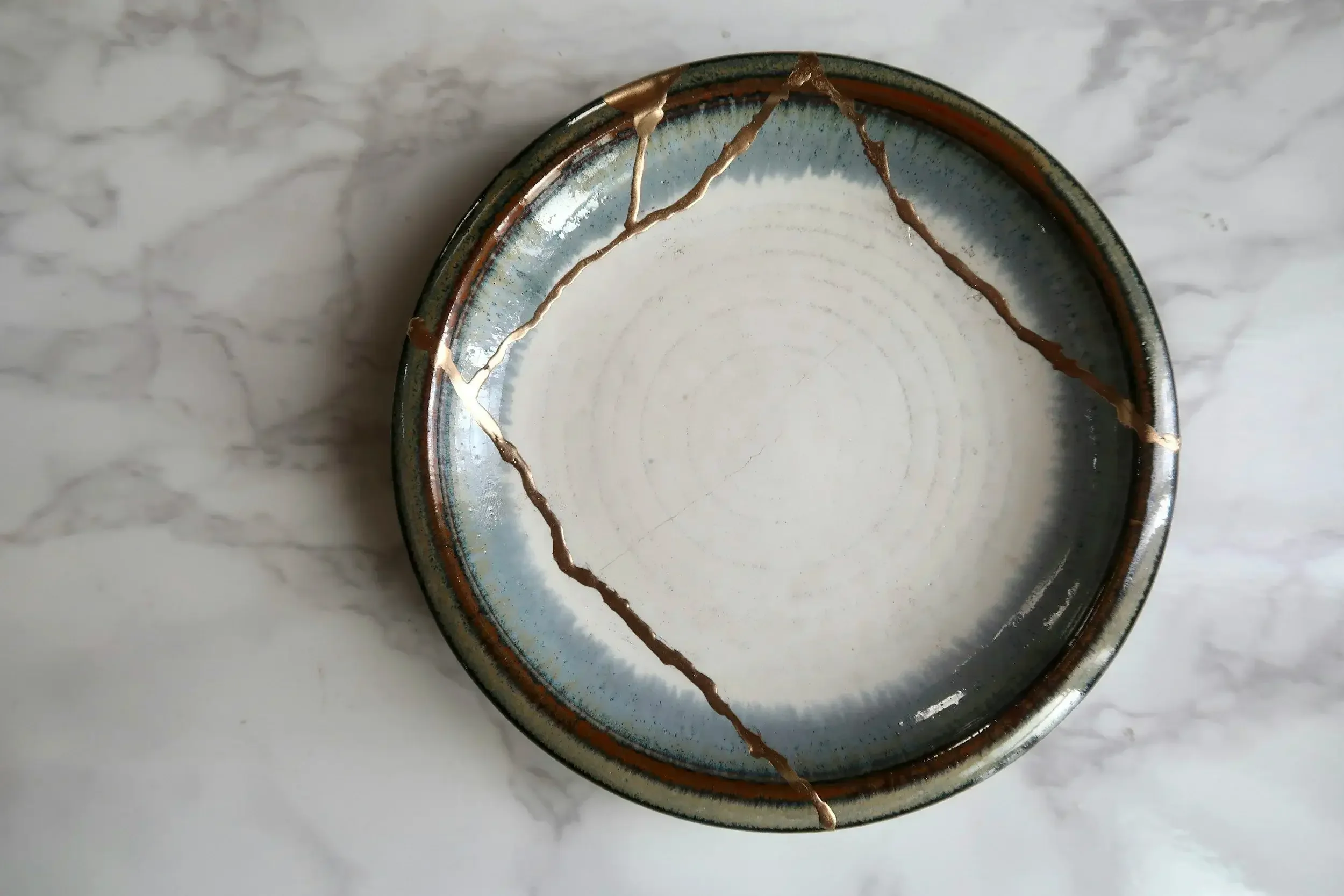 Photo of a Japanese kintsugi bowl, in which a broken bowl has been mended with gold, representing how past hurts can strengthen us just like trauma. A trauma therapist can help you heal. 90232 | 90069 | 90027