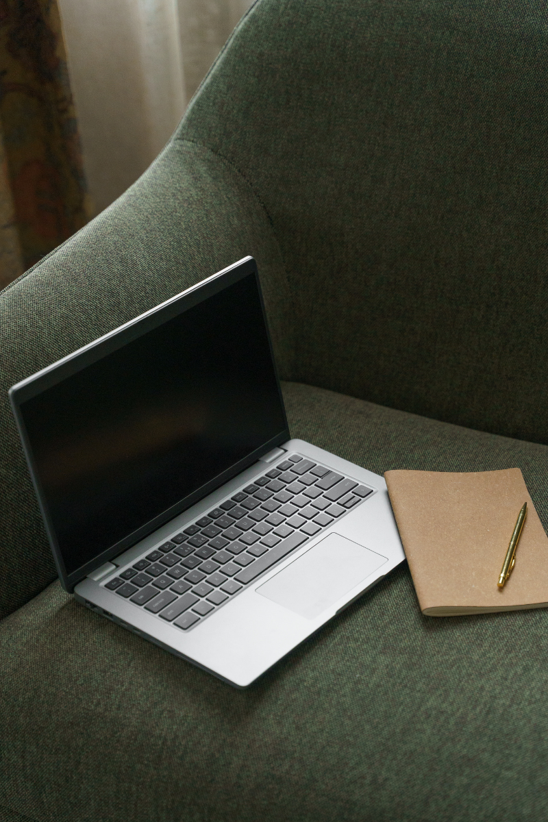 Photo of a laptop on a green sofa representing connecting with your therapist online. Well Woman offers virtual sessions in California, Colorado, Illinois, New York and Washington. 90277 | 90402 | 90015