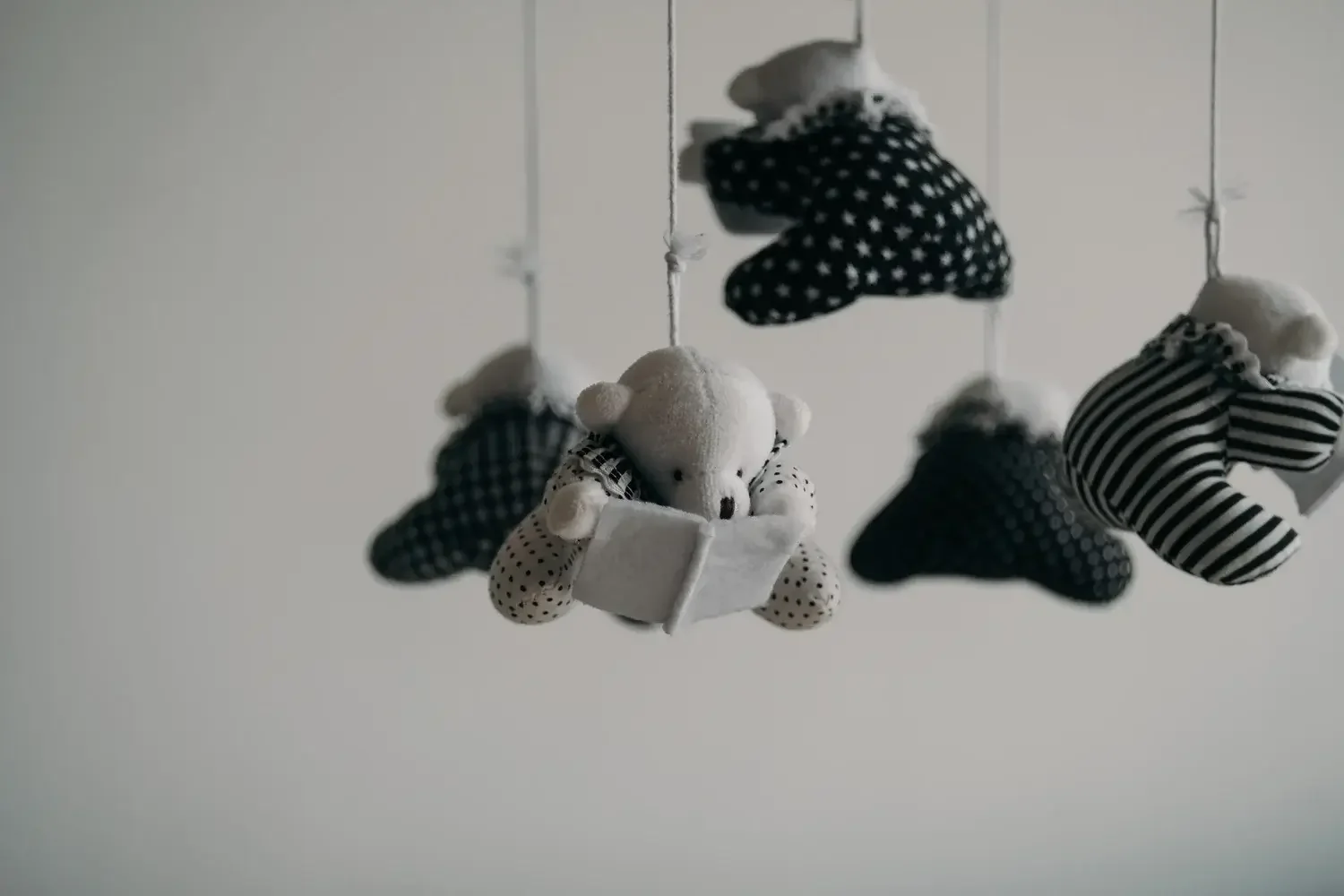 A black and white photo of a baby mobile showing how painful it is when others are having babies when you are struggling with infertility. An infertility therapist in Los Angeles can help you cope as a part of infertility and relationship therapy in