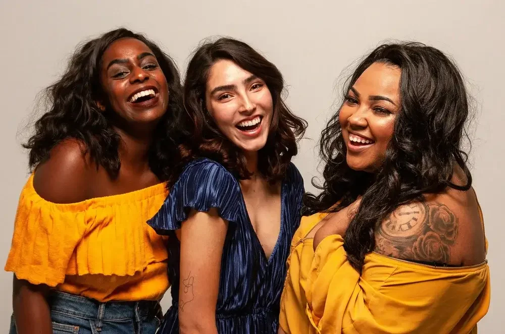 Photo of 2 women smiling, one straight sized, one with a larger body, both dressed in jewel tones, representing people living their best most authentic lives. 90094 | 90401 | 90274