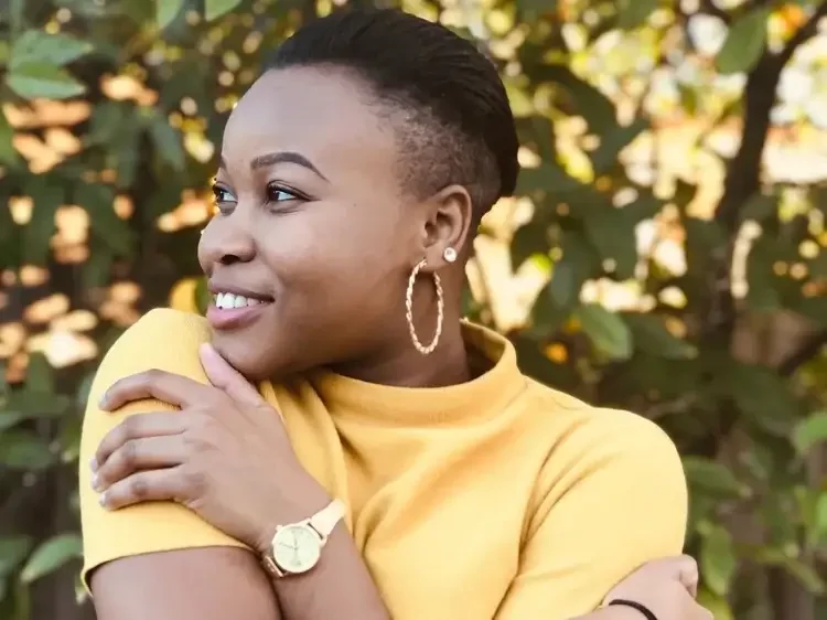 Image of a Black woman in a yellow shirt hugging herself. In therapy for relationship issues in Los Angeles, I will help you with healthy attachments as an online psychologist. 90266 | 90277 | 90402