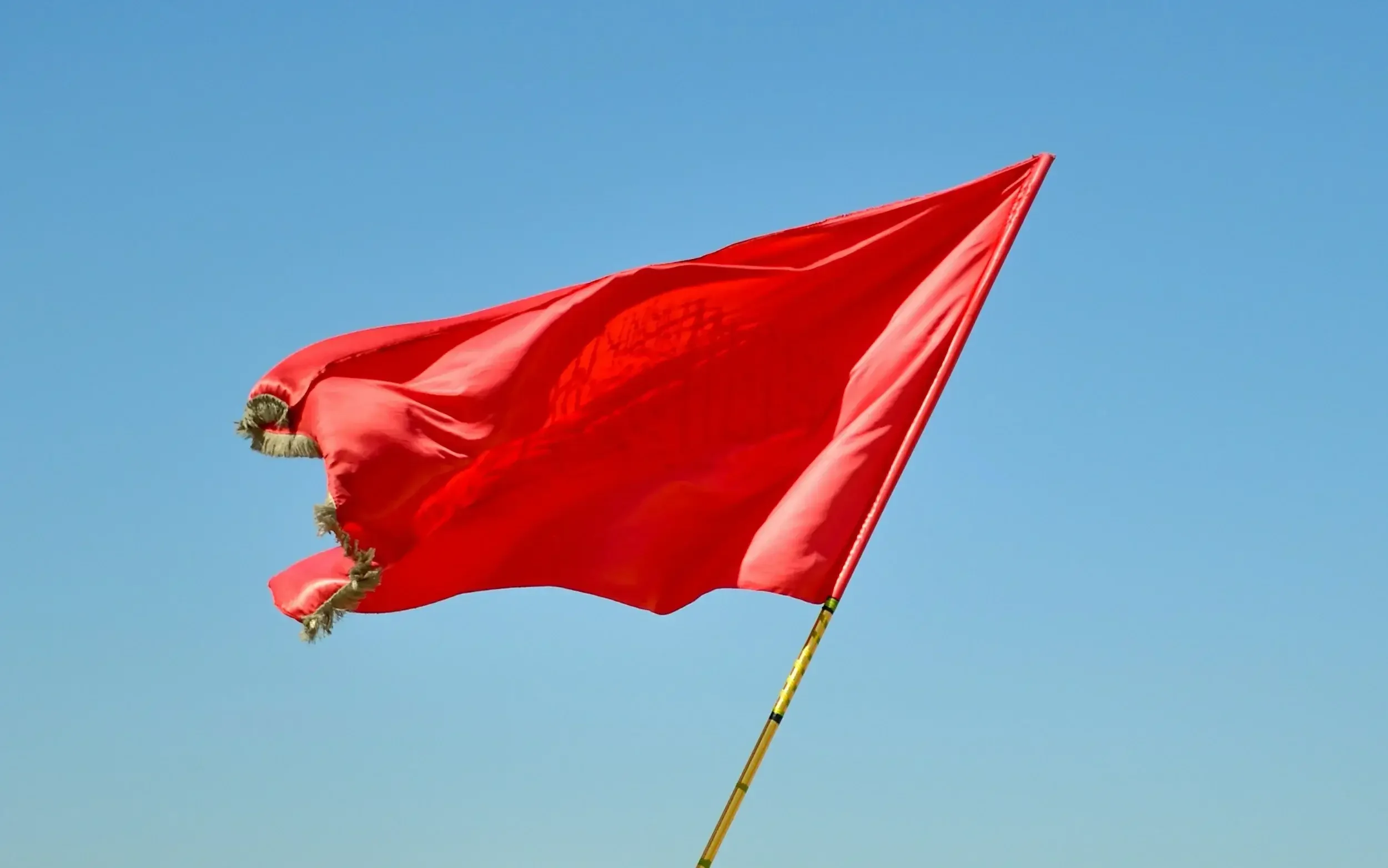 Photo of a red flag to represent the tendency of trauma survivors to overlook red flag behavior in others. A trauma therapist specializing in women can help you learn how to heal and have healthy relationships. 90405 | 90274 | 90254