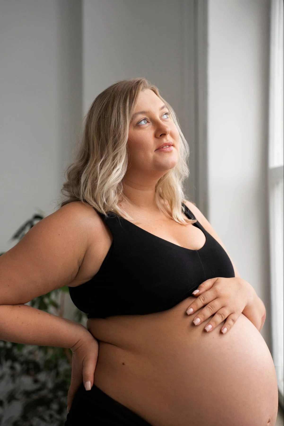 A pregnant woman looking content and holding her belly depicting supportive pregnancy mental health therapy for emotional wellbeing during pregnancy. 90277 | 90402 | 90015