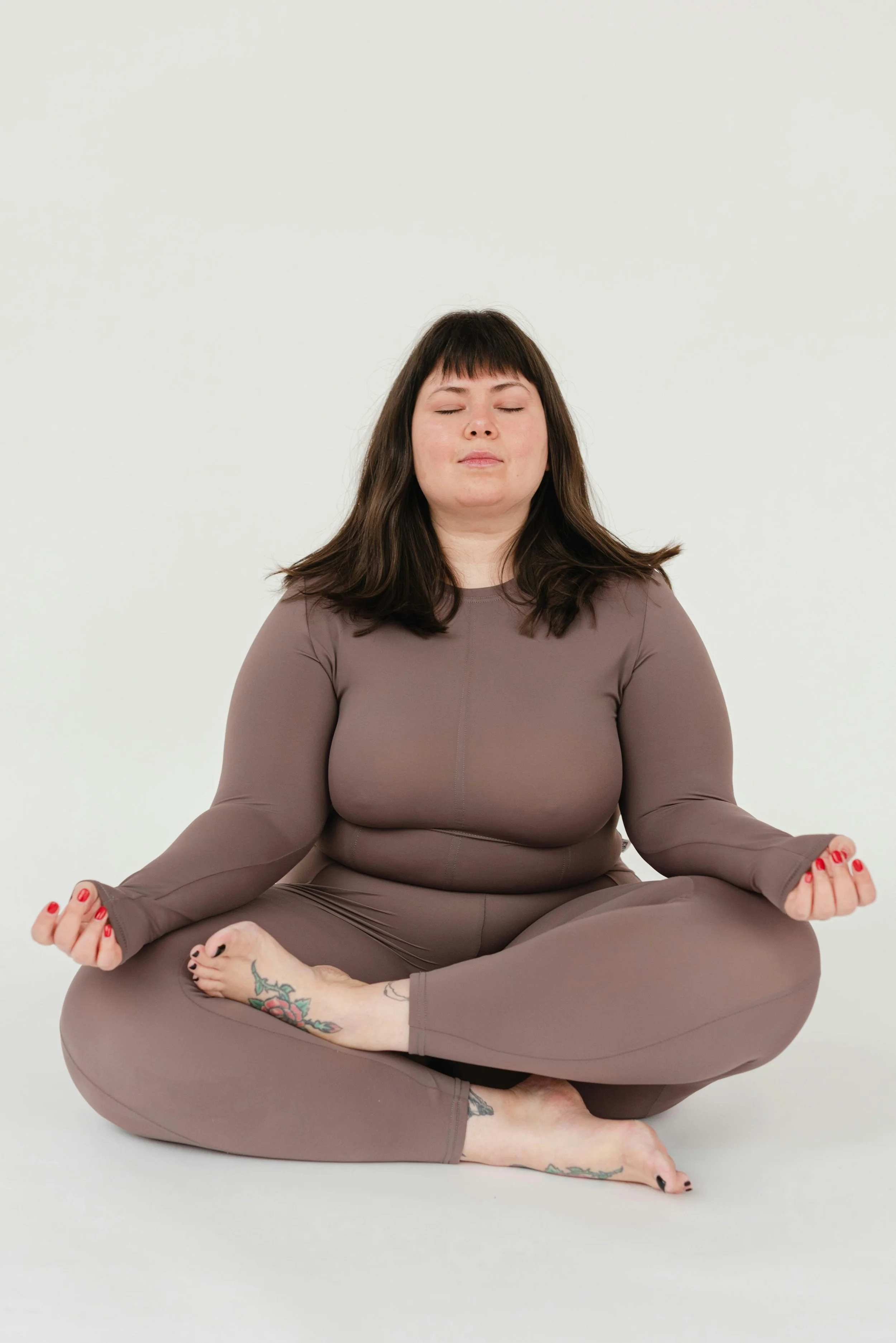 Photo a woman meditating, representing women trying to find peace in their bodies. An online therapist specializing in body image can help. 90027 | 91105 | 91436