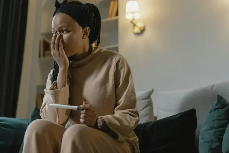 Picture of a woman holding a pregnancy test, looking shocked. Therapy in Chicago can help you with infertility issues. 60432 | 60540 | 61101 |
