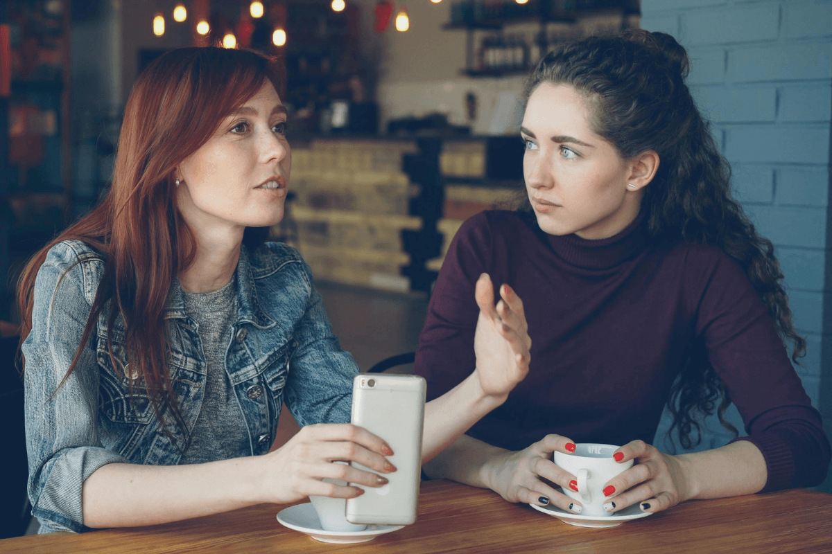 2 women speaking in a coffee shop which represents the shared experience of violence that women face. If you'd like help to navigate sexual abuse, coercive control or patriarchy Well Woman Psychology is here 90402 | 90015 | 90266