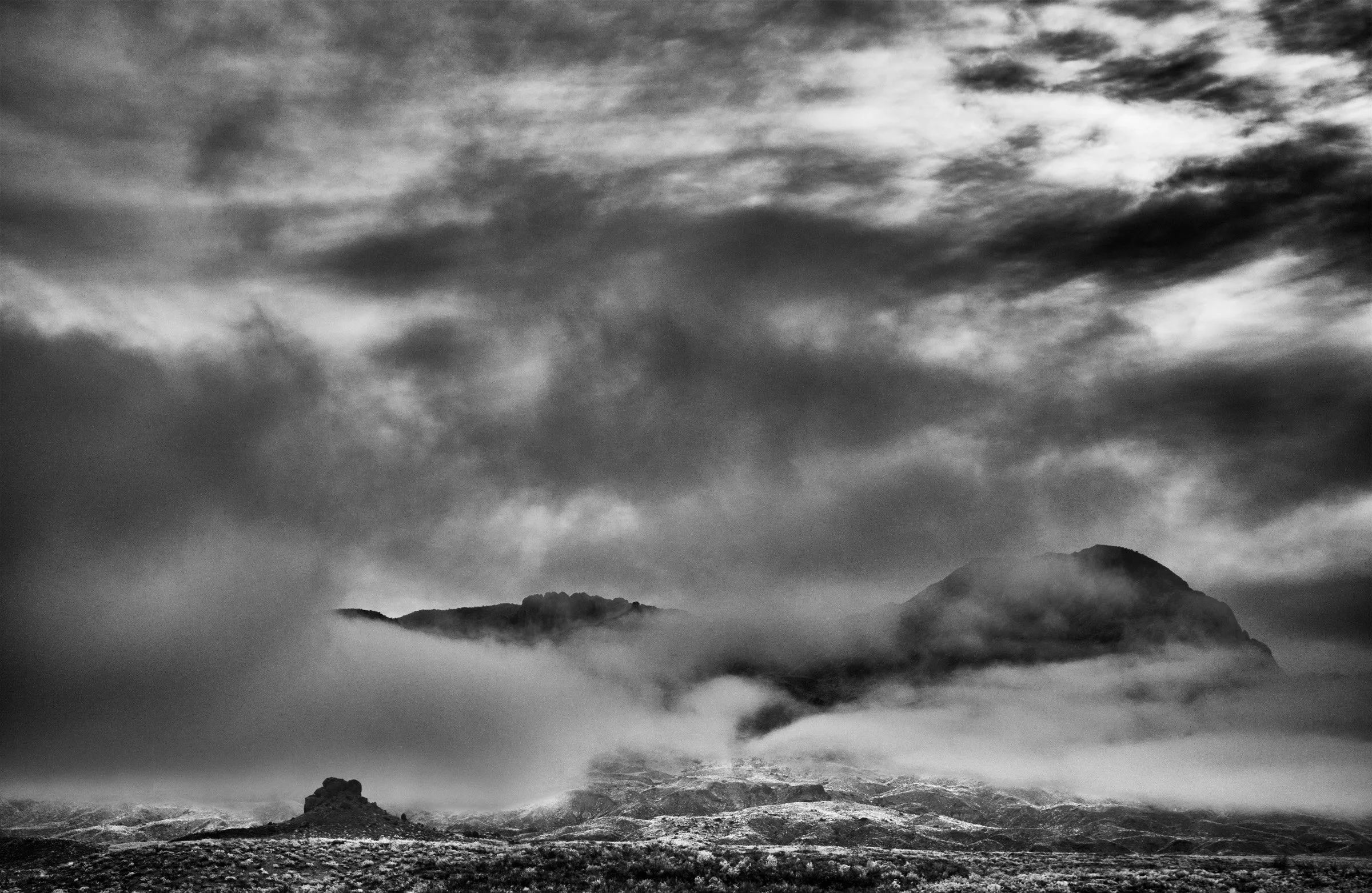 Mountains in a Cloud Sea - A cloud sea climbs to the ridgelines and breaks around the higher forms, turning the range into a handful of silhouettes above the field at Big Bend.