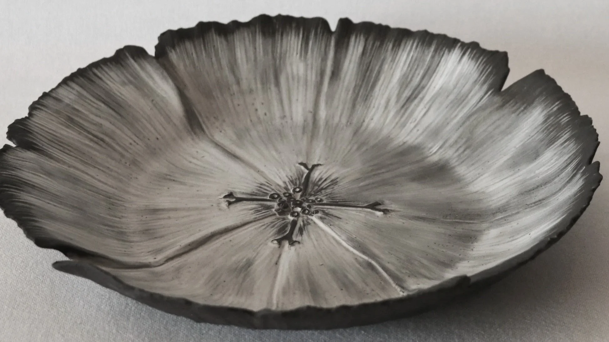 A delicate hand sculpted ceramic flower sculpture in black and white. handmade in New Zealand from black stoneware clay.