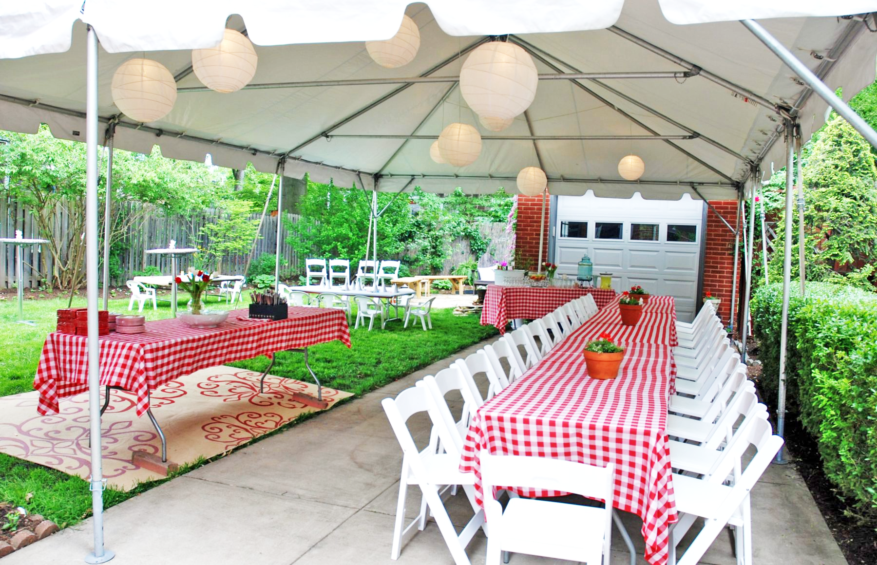 Tables with red checkered covers set up beneath a tent