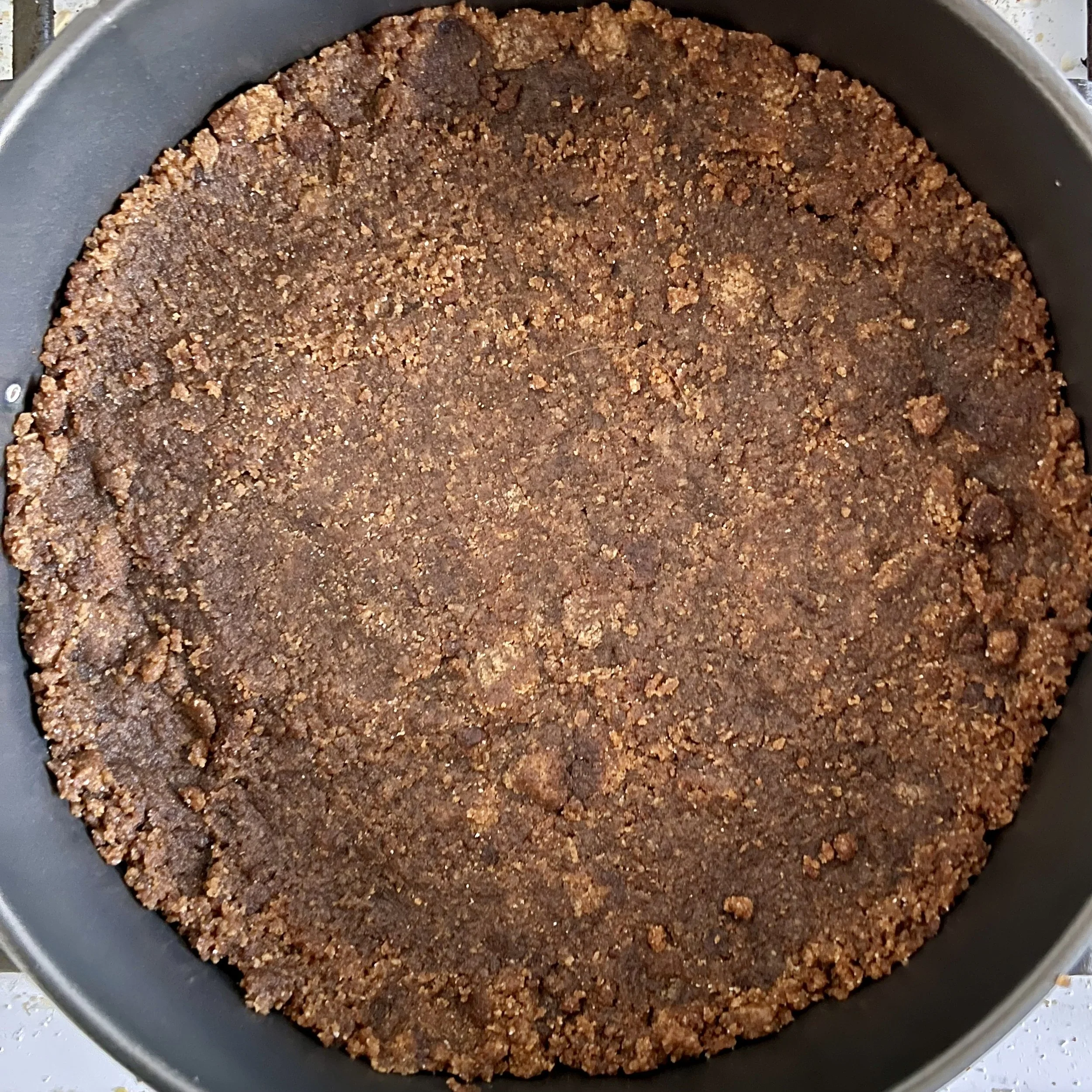 A cheesecake bottom made of gingersnap pieces and butter.